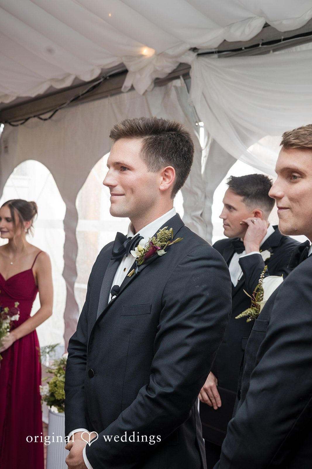 Macy + Nolan A groom in a black tuxedo looking to the side during the ceremony.