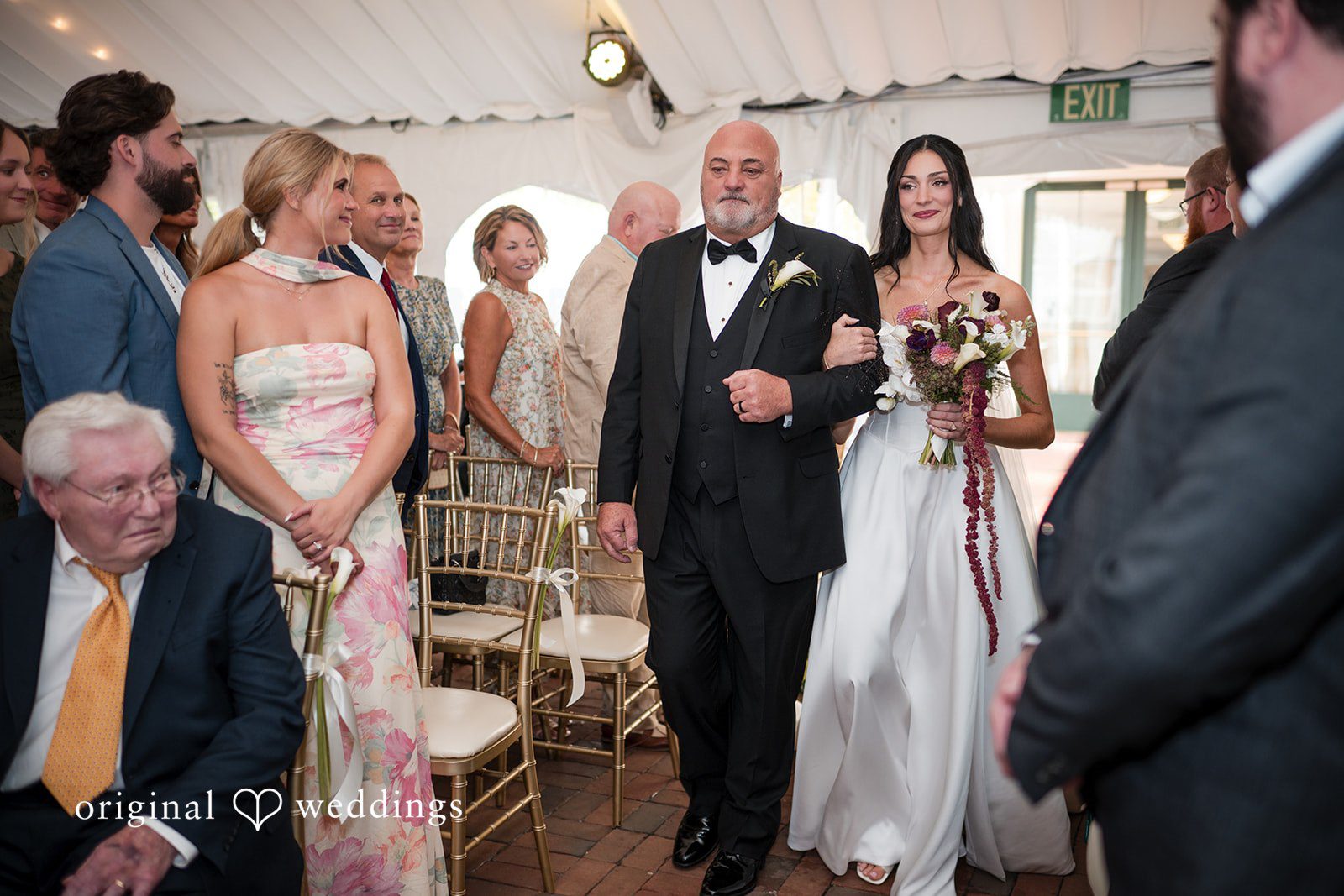Macy + Nolan A bride walking down the aisle accompanied by an older man.