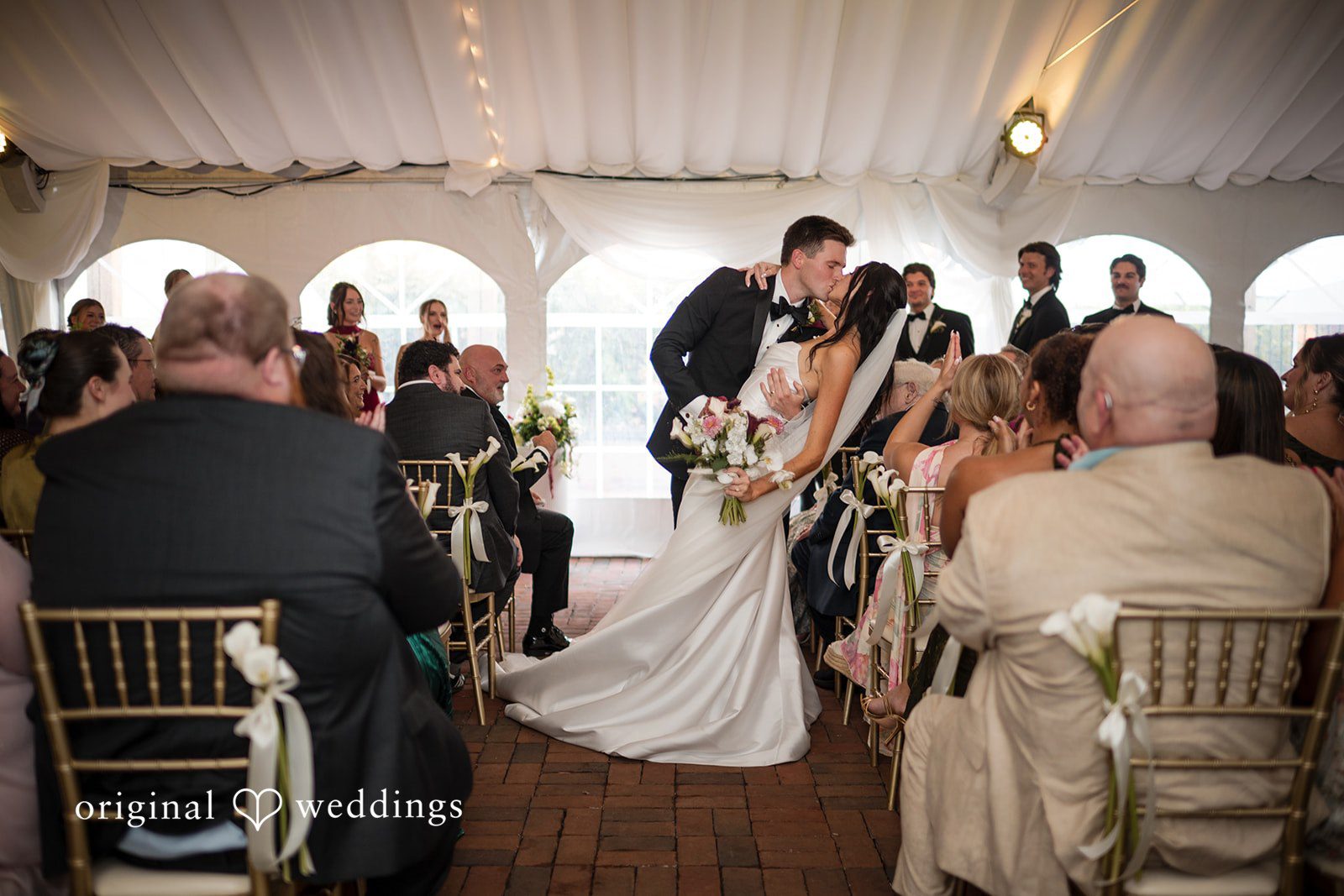 Macy + Nolan A reception scene showing guests seated at chairs under a tent.