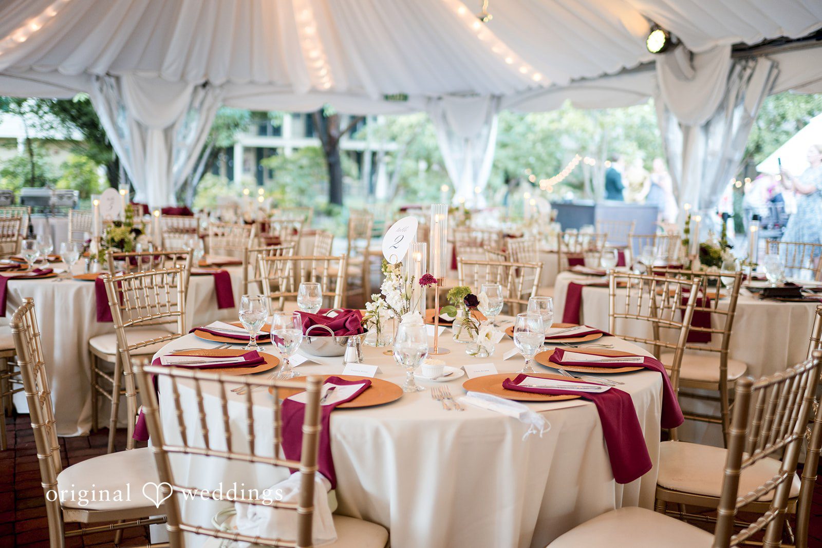 September 12, 2026 – Macy & Nolan – (ID-4760) A decorated reception room filled with dining tables and gold chairs under a tent.