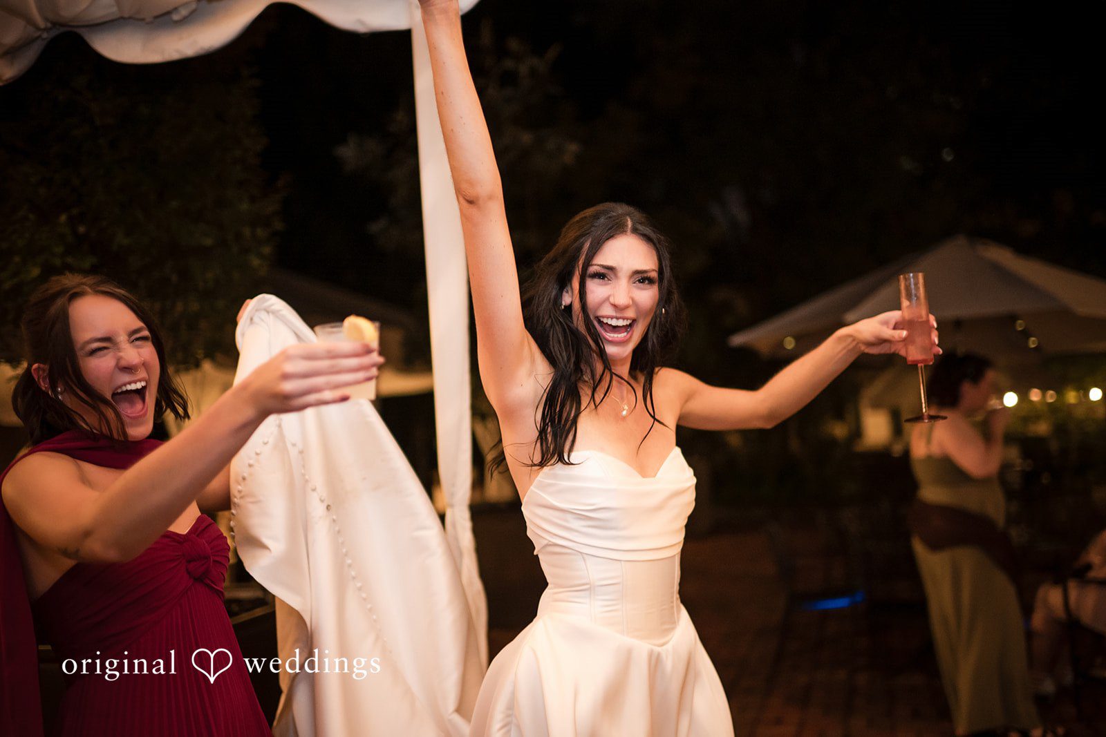 Macy + Nolan A bride dancing with her arms raised in the air during a reception celebration.