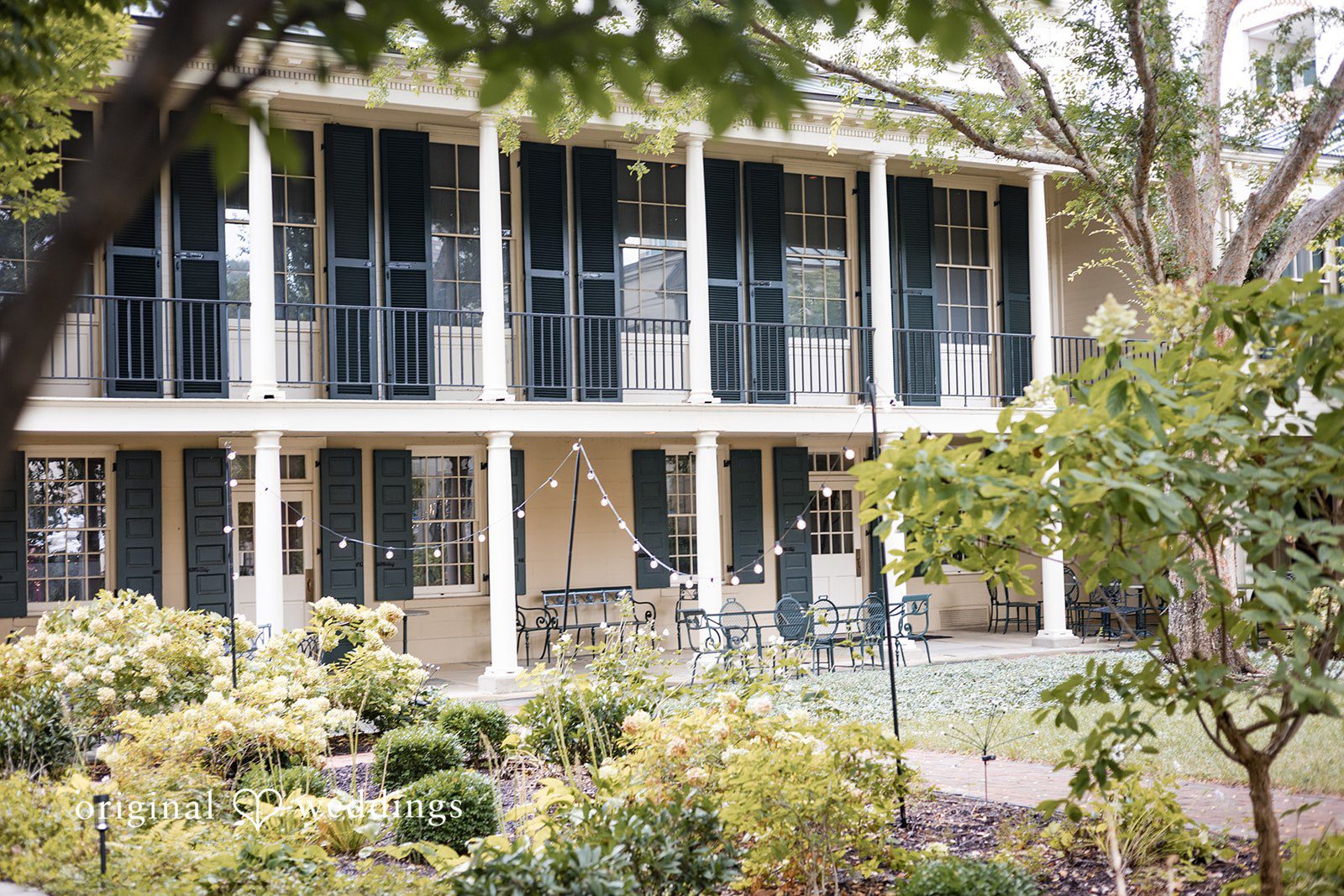 Macy + Nolan A multi-story historic venue with columns and surrounding trees.