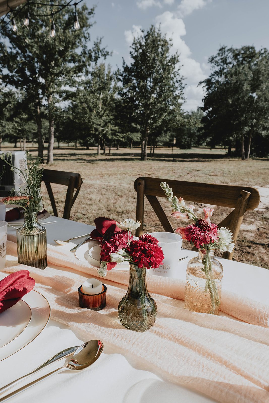 texas-backyard-rustic-austin-megan-kyle-p004-10 Table with red flowers and place settings