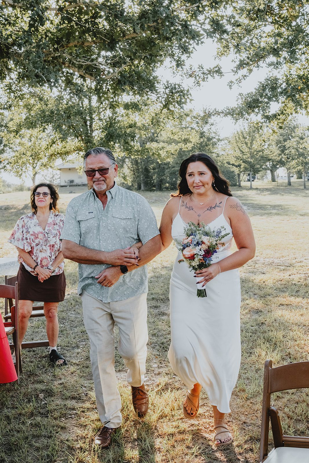 texas-backyard-rustic-austin-megan-kyle-p010-04 Bride walking down the aisle with her family
