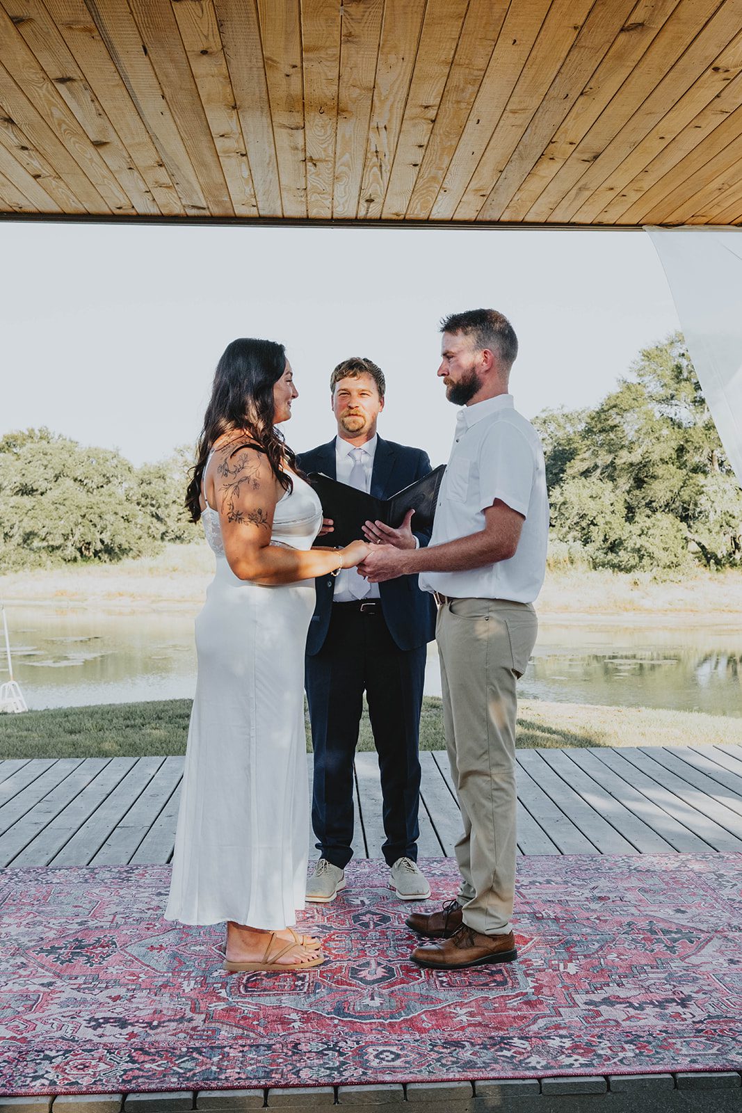texas-backyard-rustic-austin-megan-kyle-p012-08 Couple exchanging vows with the officiant