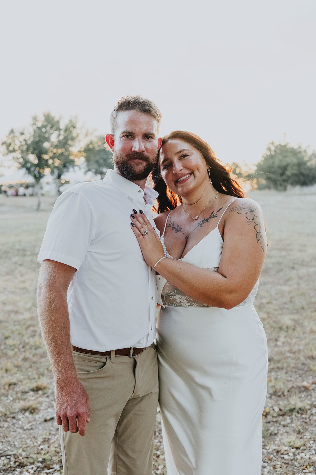 texas-backyard-rustic-austin-megan-kyle-p018-07 Bride and groom smiling together in the field at their Texas backyard wedding