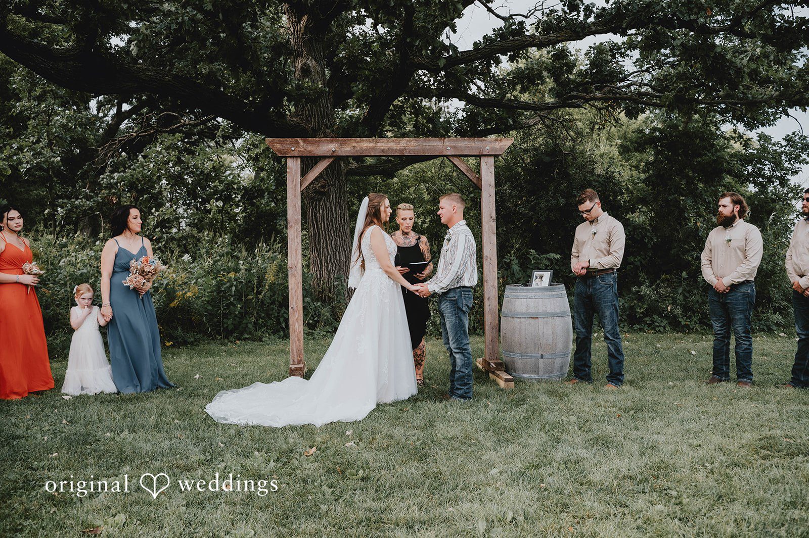 Ceremony with the wedding party at the arch at The Barn at Ballard Creek