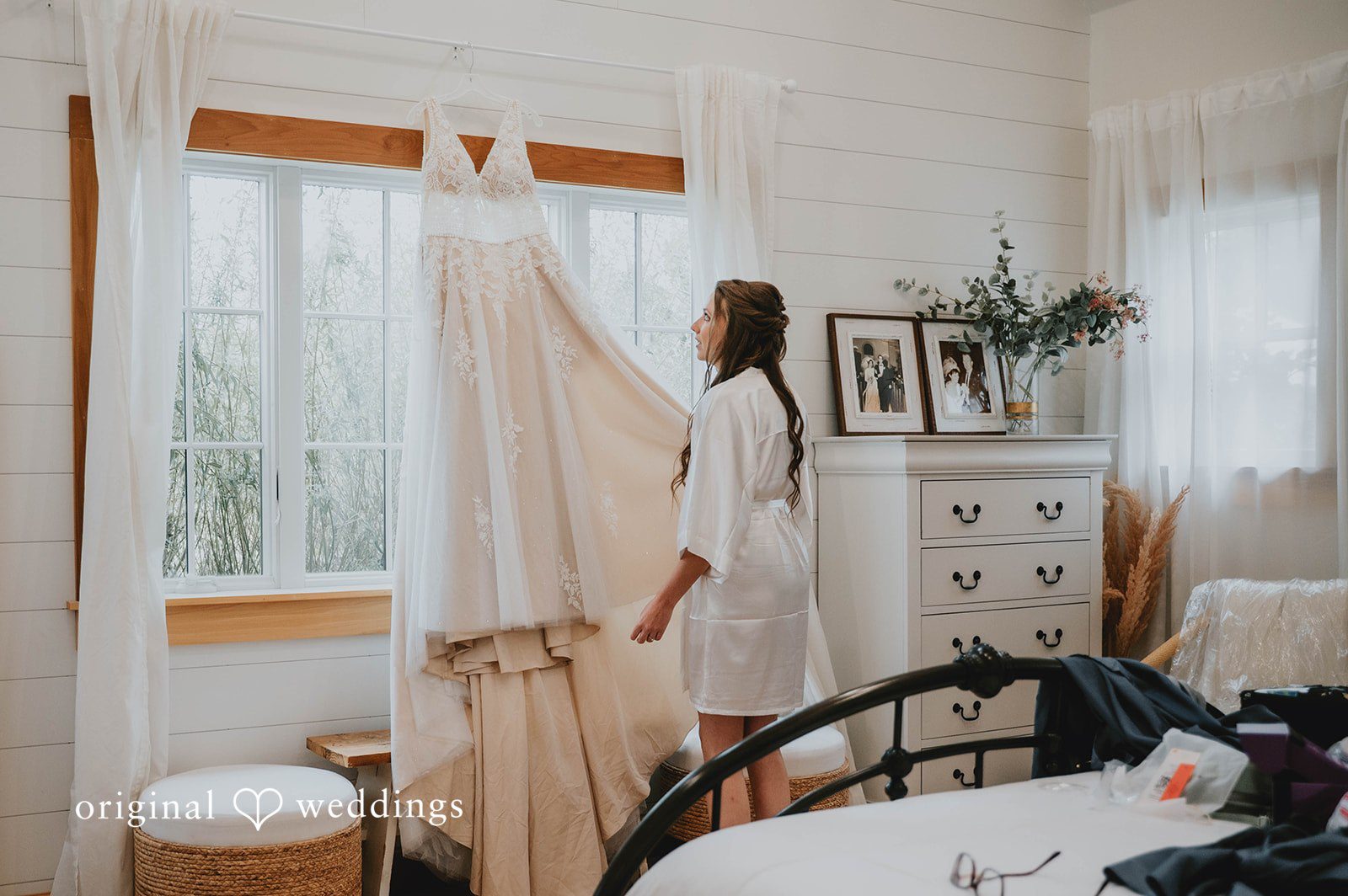 Bride with her dress hanging by the window