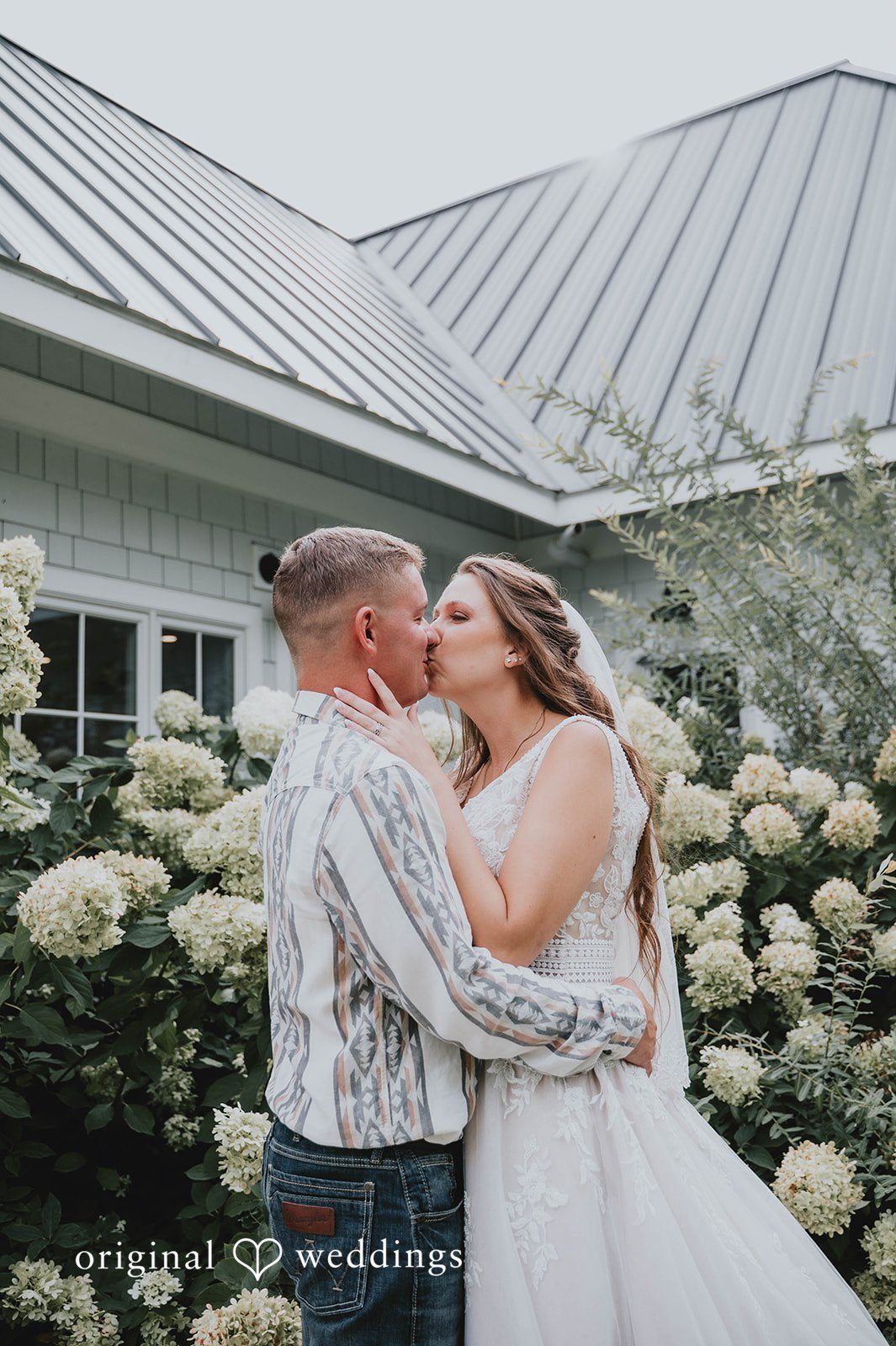 Couple kissing by the farmhouse