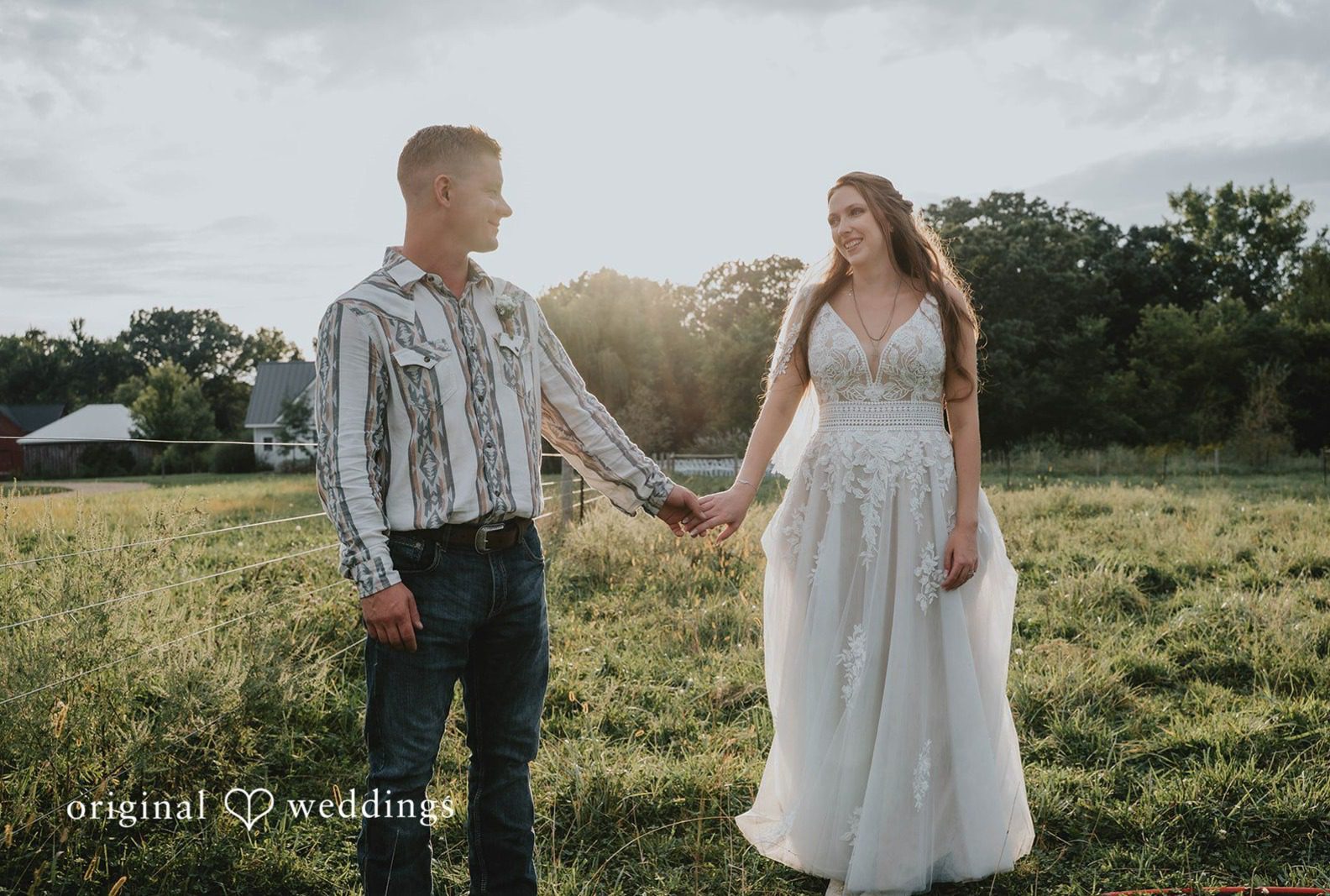 Couple holding hands in the field, captured by Minneapolis wedding photographers from Original Weddings at The Barn at Ballard Creek