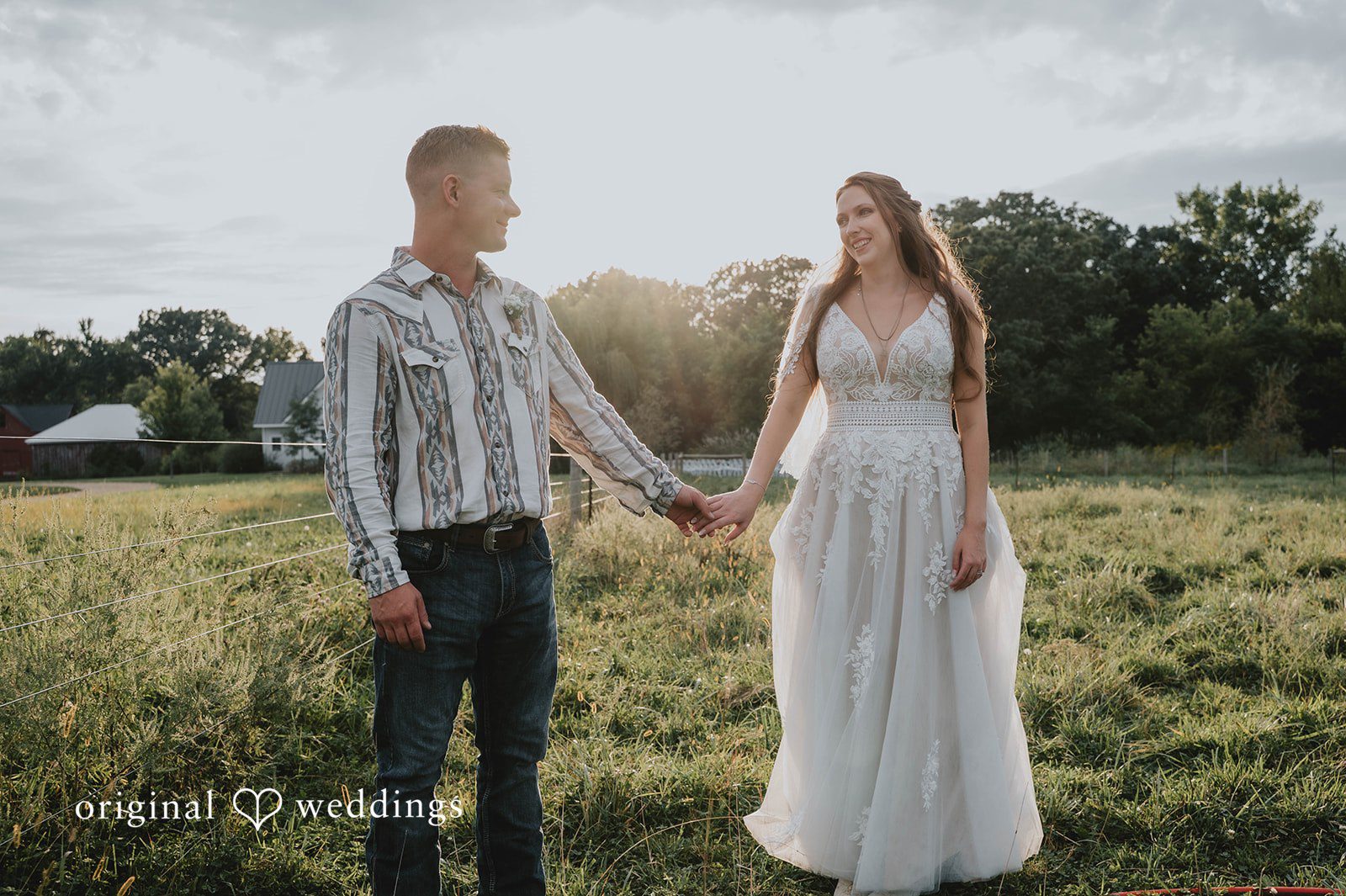 Couple holding hands in the field, captured by Minneapolis wedding photographers from Original Weddings at The Barn at Ballard Creek