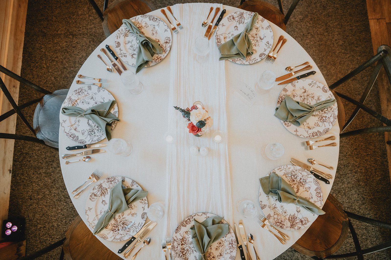 Round table with a floral centerpiece at The Barn at Blackstone National Round table with a floral centerpiece at The Barn at Blackstone National
