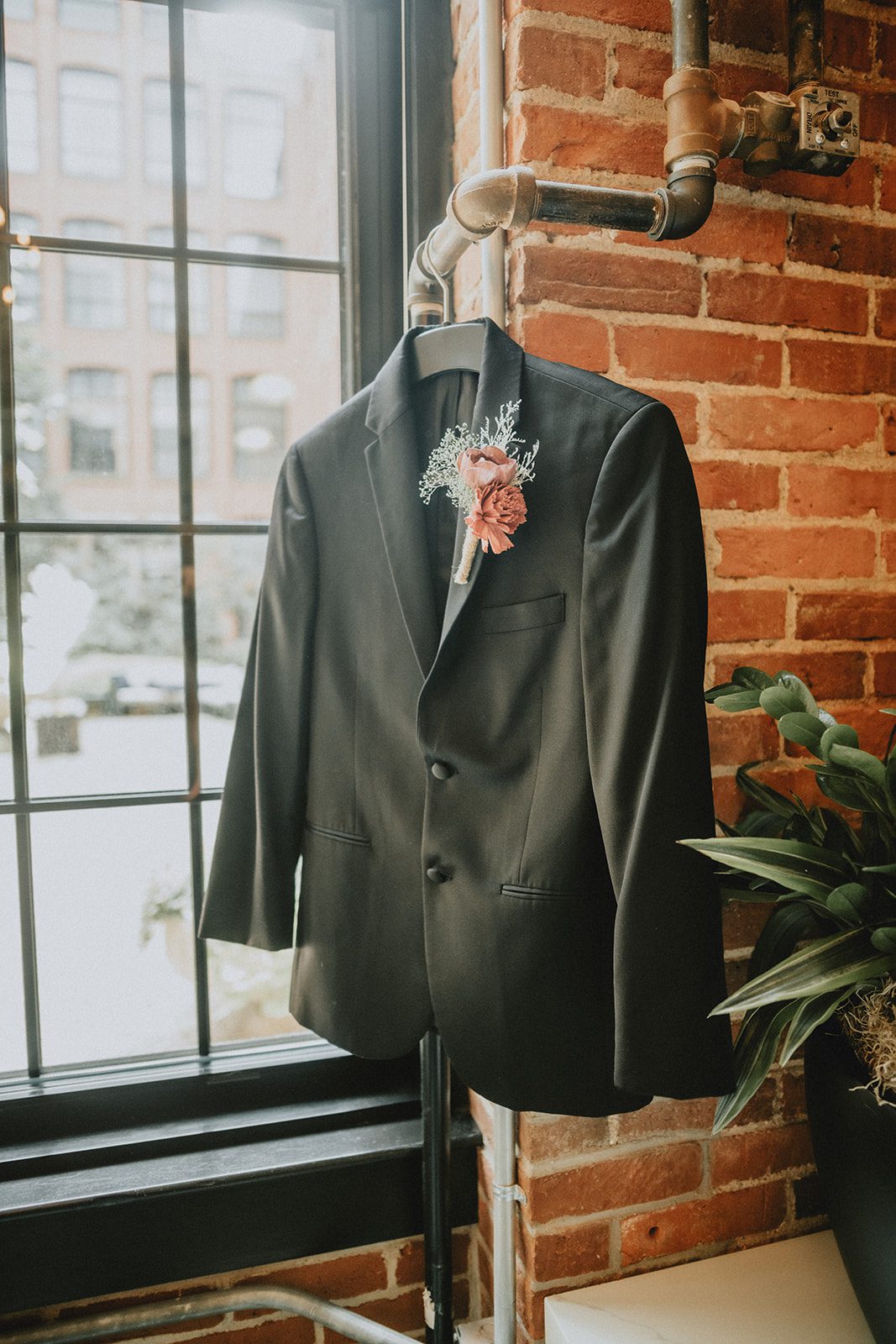 Groom's suit jacket hanging by the window Groom's suit jacket hanging by the window