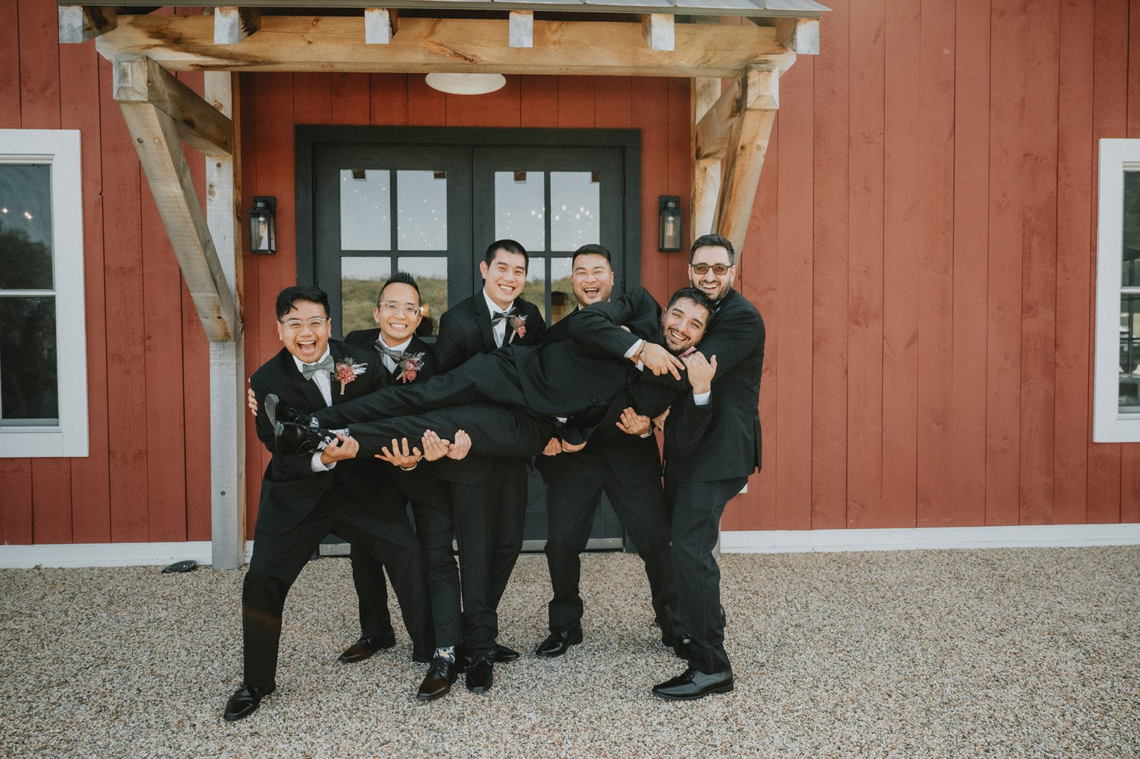 Groomsmen having fun outside the barn at The Barn at Blackstone National Groomsmen having fun outside the barn at The Barn at Blackstone National