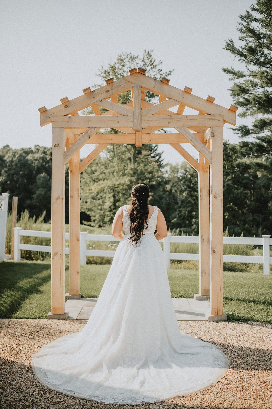 Bride under the wooden arbor at The Barn at Blackstone National Bride under the wooden arbor at The Barn at Blackstone National