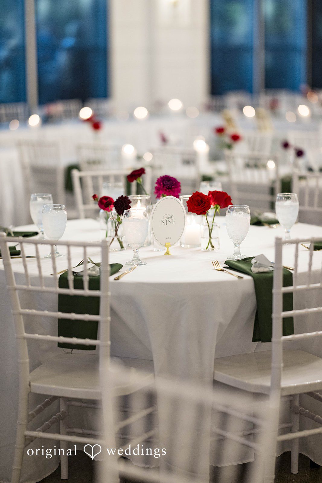 Andrea + Roberto Reception table with burgundy roses and candles at The Crawford