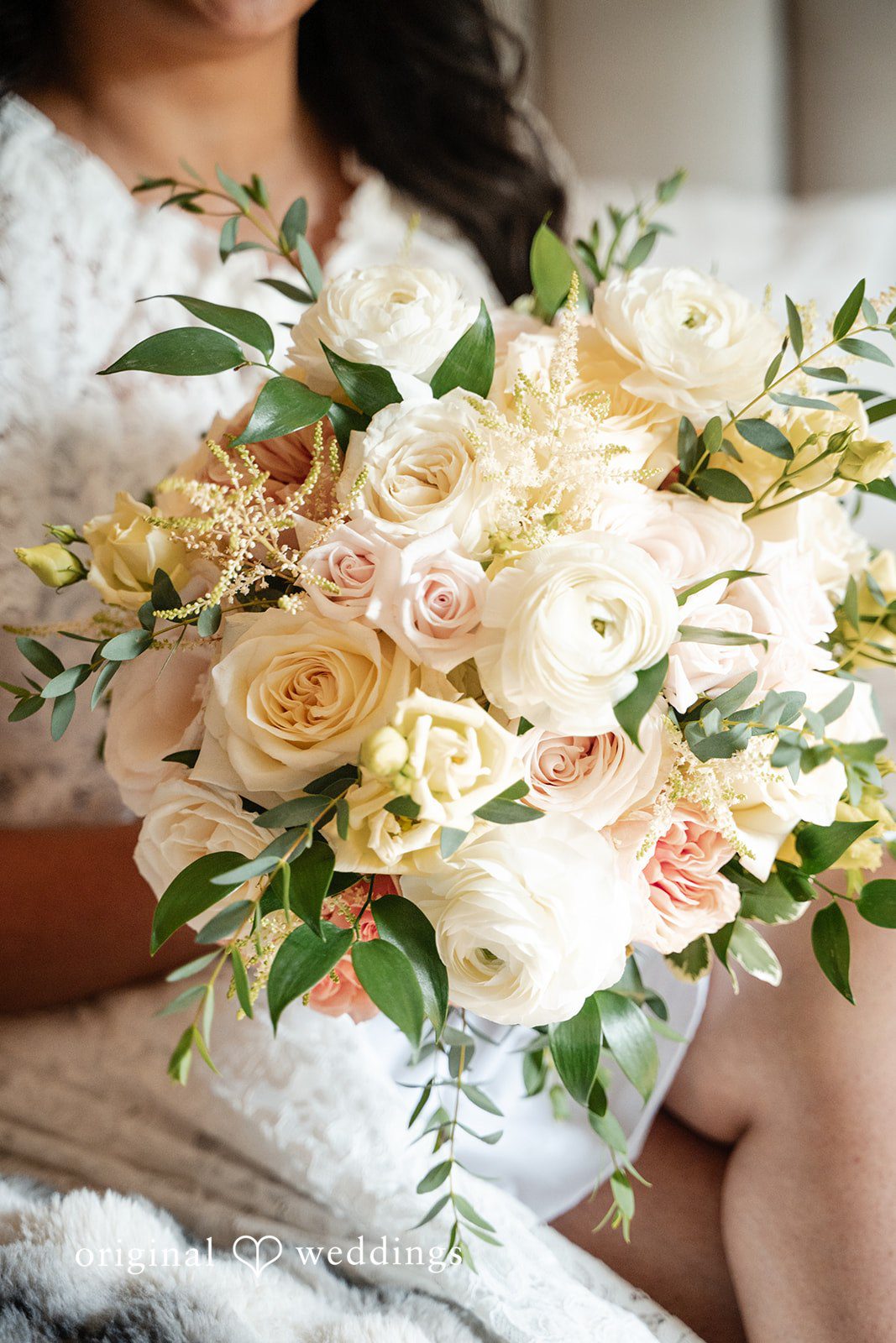 Selena + Ezequiel A close-up view of a bridal bouquet made of white and light pink roses.