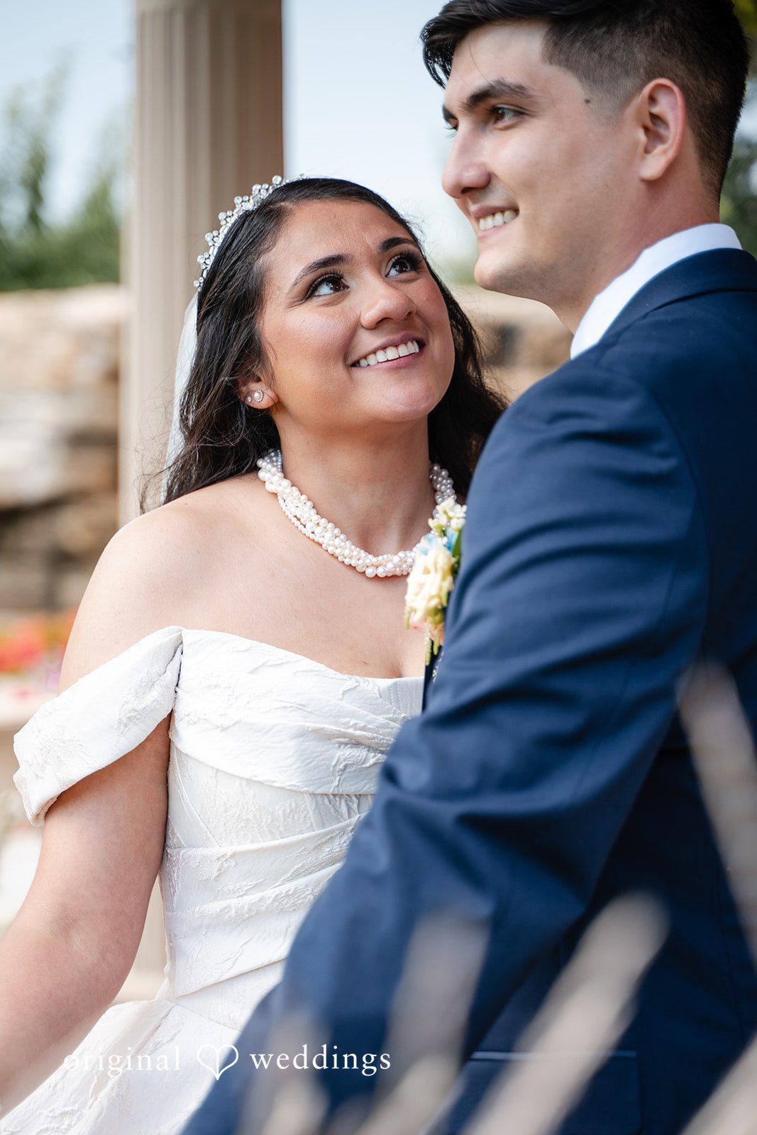 Selena + Ezequiel A close-up portrait of a smiling bride and groom looking affectionately at each other.