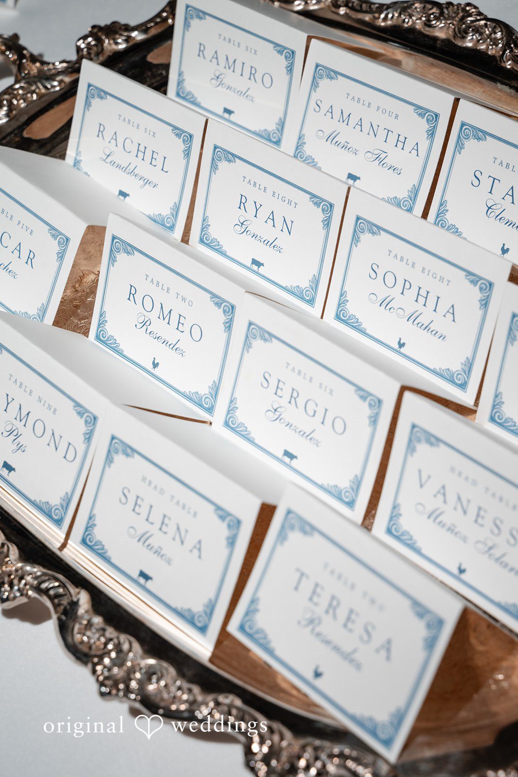 Selena + Ezequiel Rows of neatly arranged white wedding place cards laid out on a table.