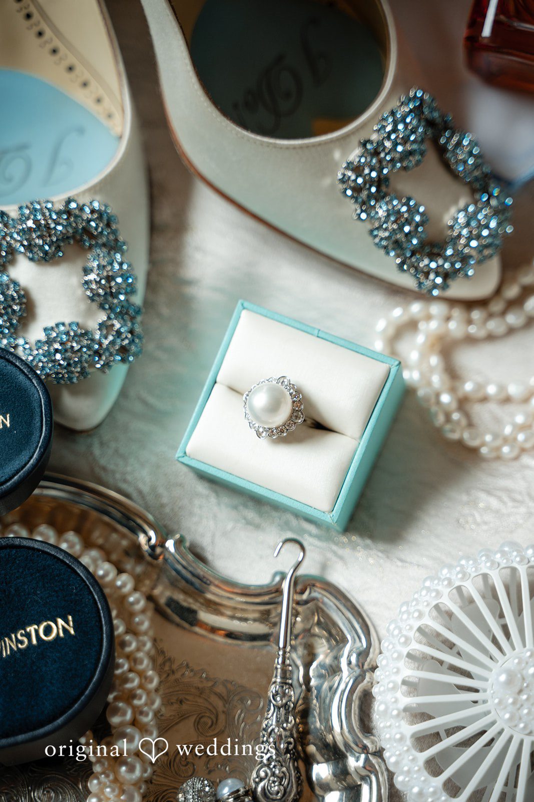 Selena + Ezequiel A silver wedding band resting inside a small light-blue jewelry box.
