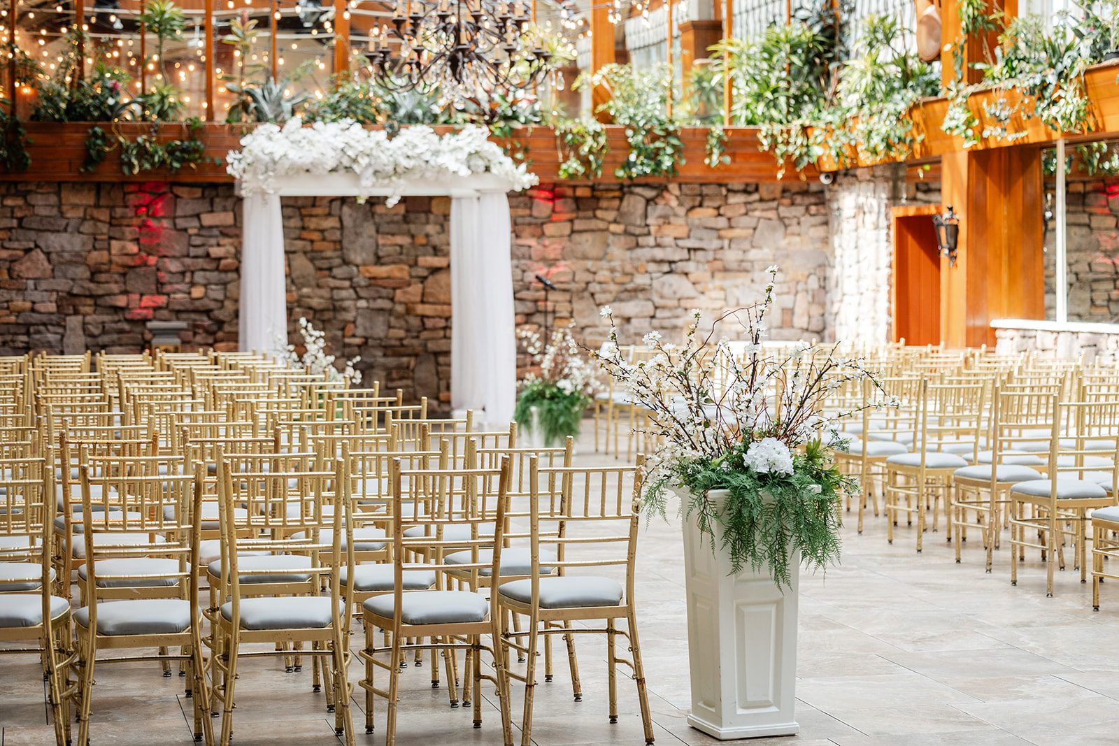 Ceremony space with stone walls and greenery at The Fox Hollow