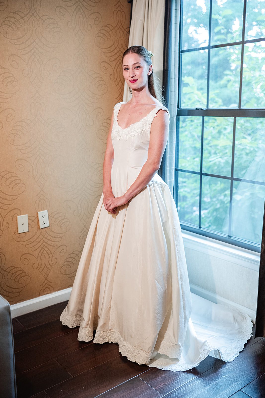 Bride by the window in her wedding dress