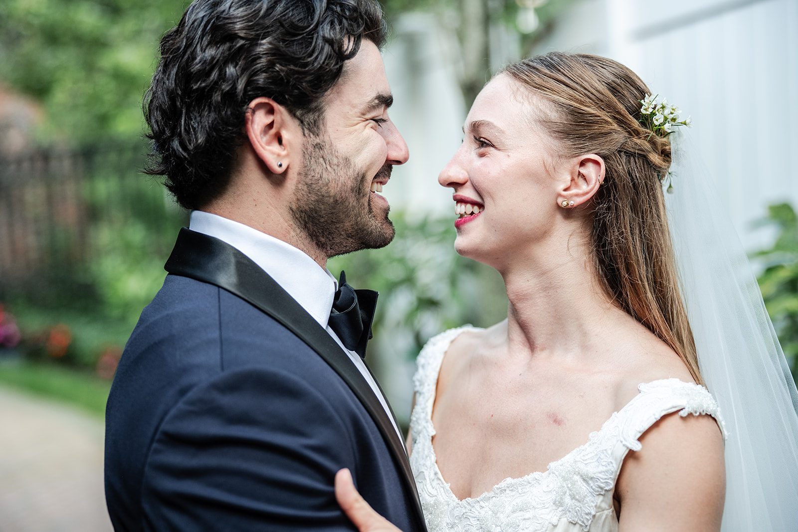 Bride and groom smiling at each other in the gardens, captured by New York wedding photographers from Original Weddings at The Fox Hollow