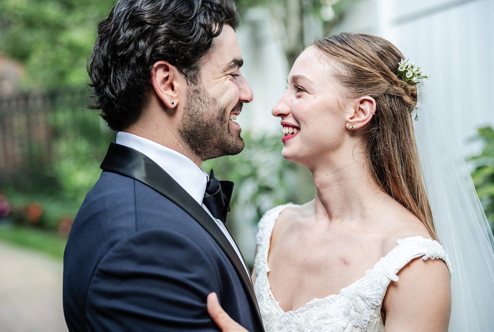 Bride and groom smiling at each other in the gardens, captured by New York wedding photographers from Original Weddings at The Fox Hollow