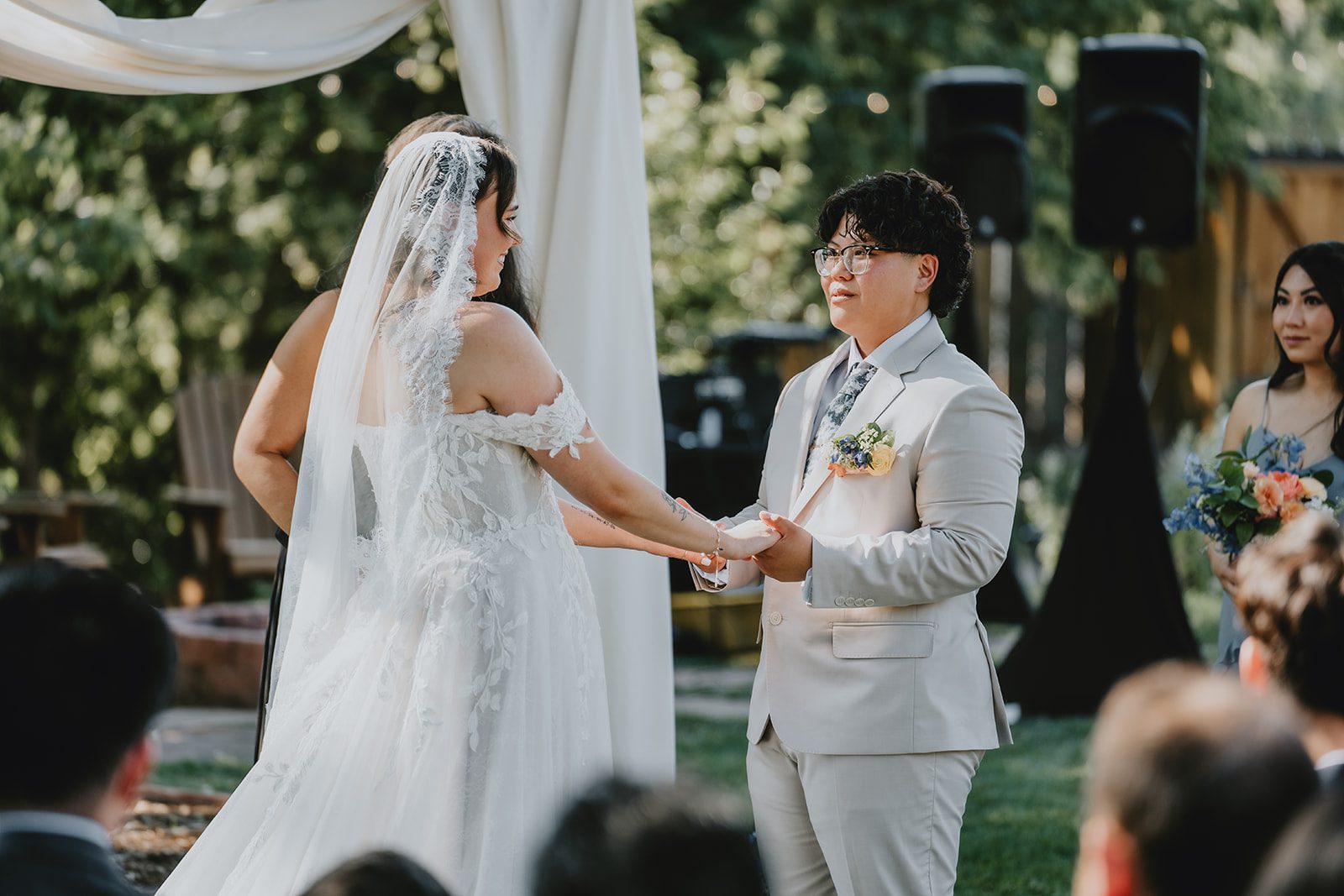 Couple exchanging vows at the ceremony arch