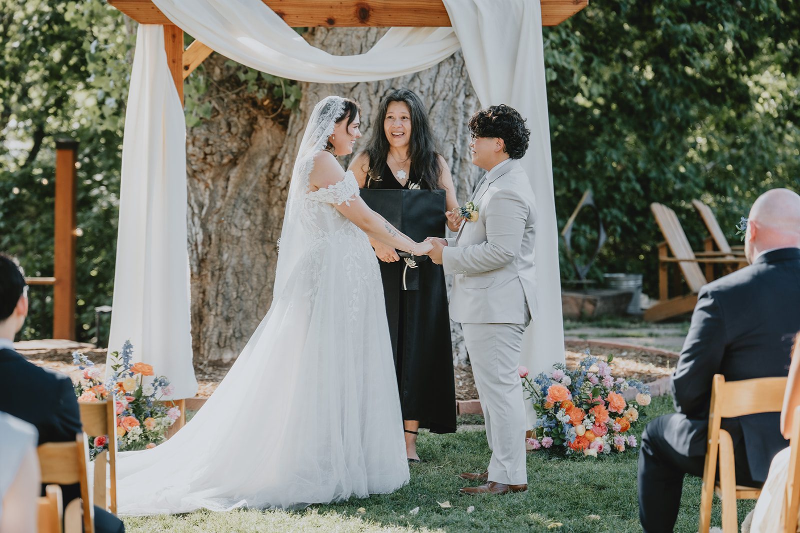 Officiant leading the ceremony under the draped arch