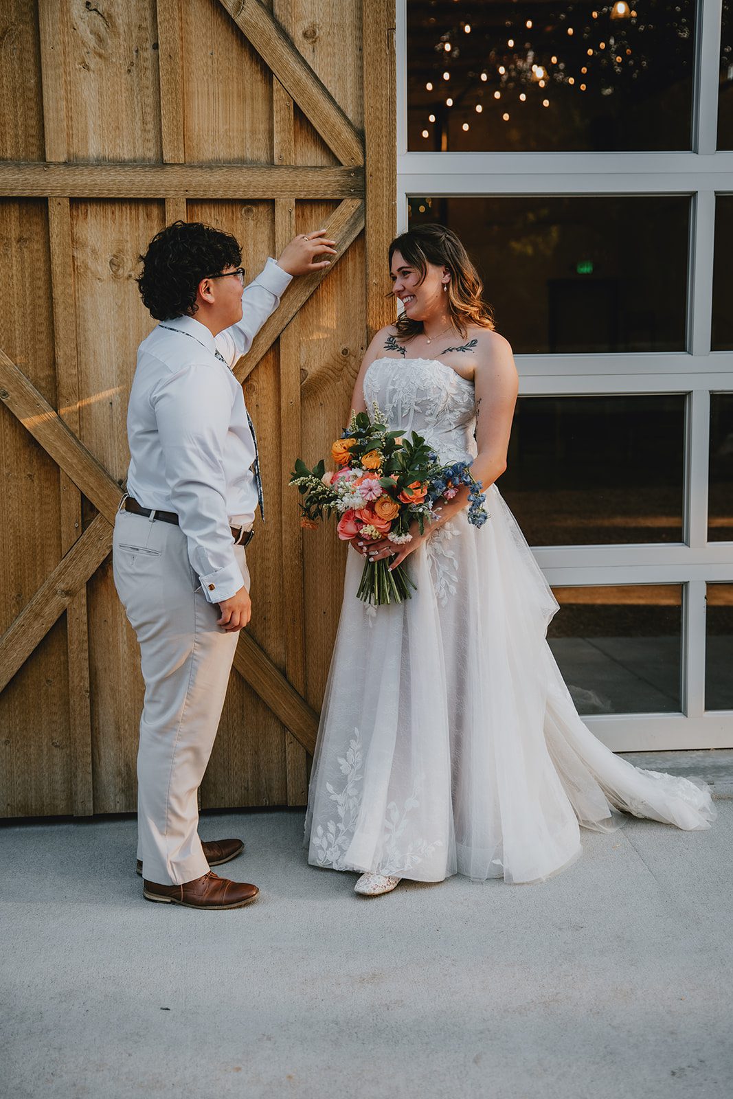 Couple posing by the barn doors at The Lyons Farmette