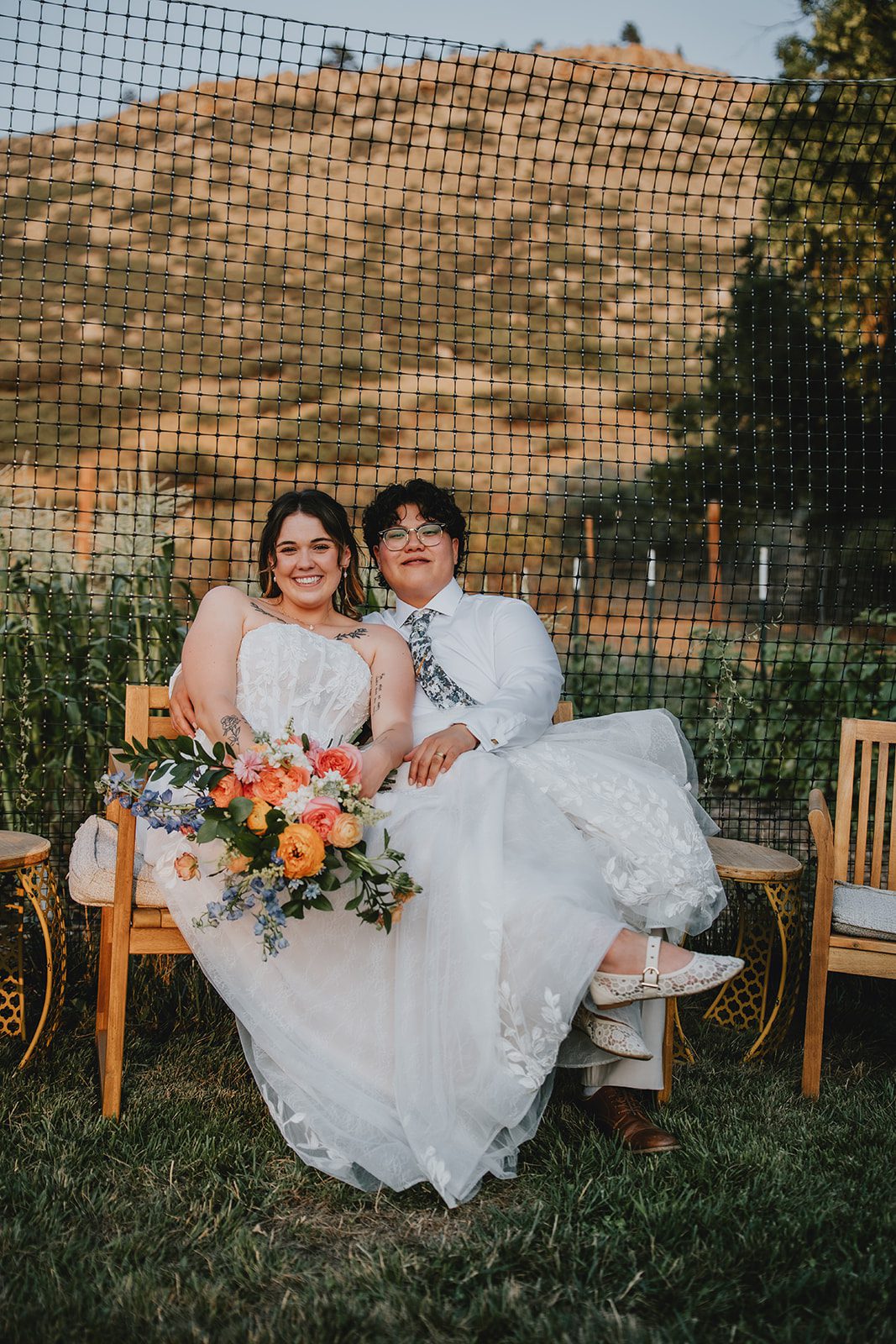 Newlyweds on a bench with mountain views