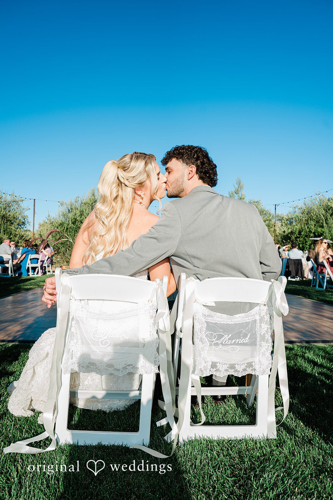 Savannah + Lucas Couple sharing a kiss on the ceremony chairs