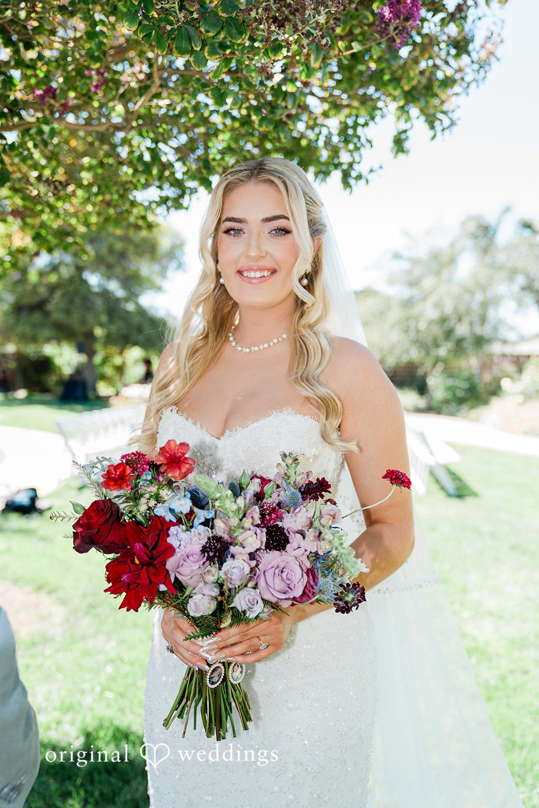 Savannah + Lucas Smiling bride with her bouquet among the olive trees at The Purple Orchid