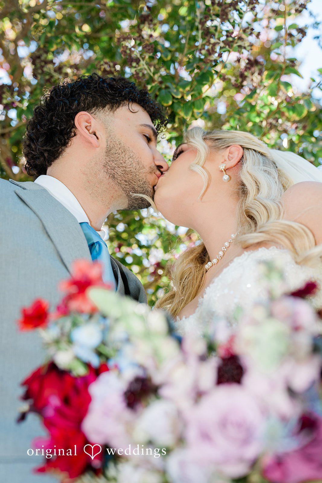 Savannah + Lucas Couple kissing behind her bouquet