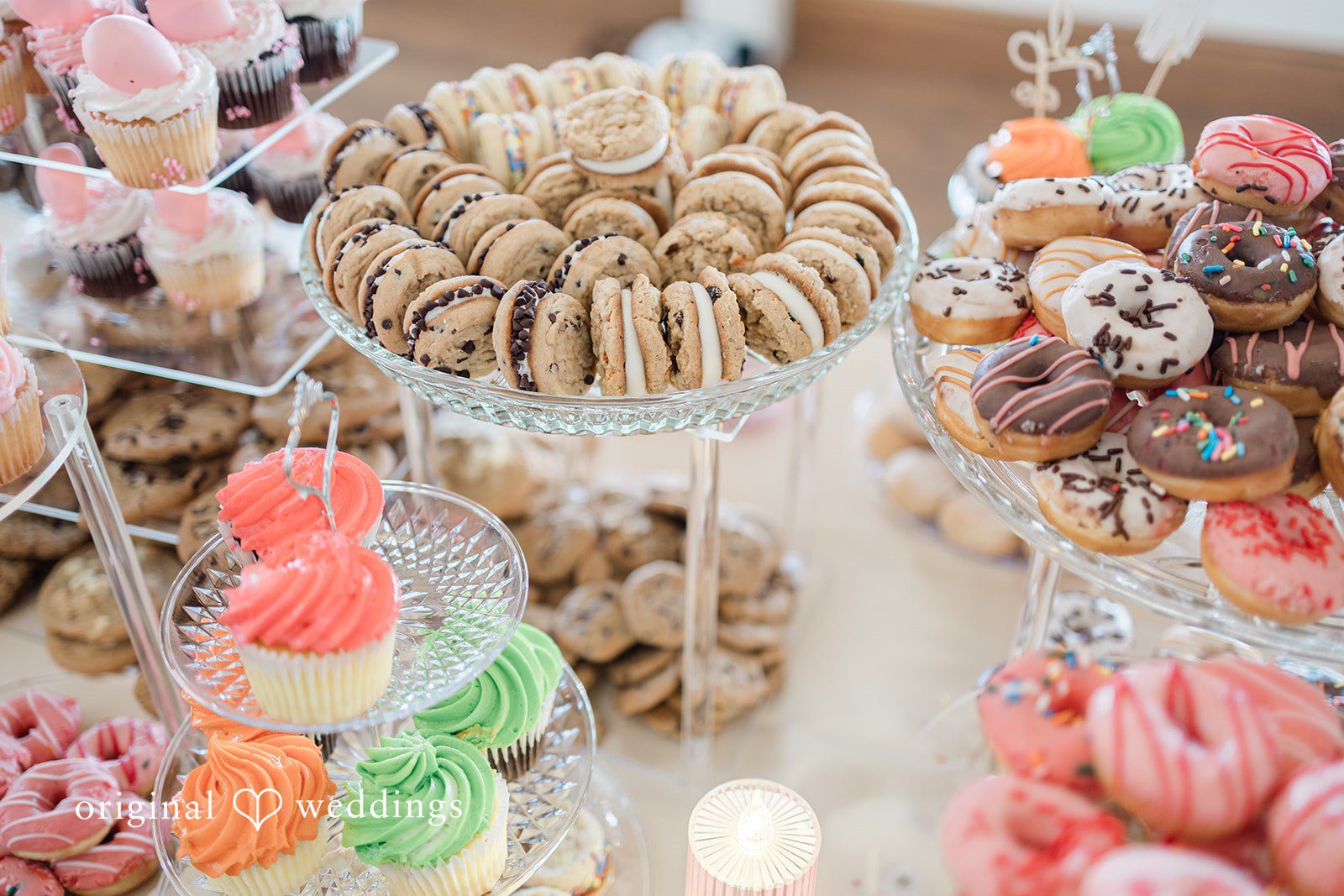 Daniel + Dalte A dessert table filled with assorted pastries, cookies, and colorful macarons.