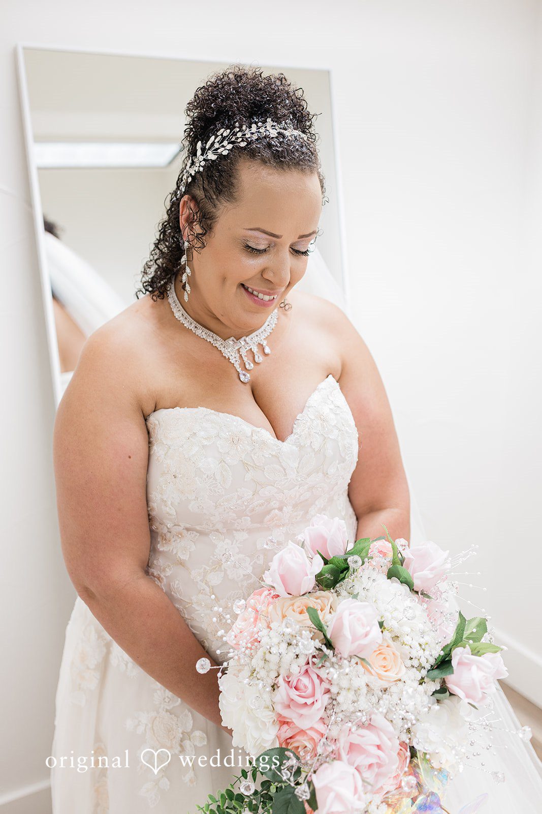 Daniel + Dalte A bride looks down affectionately at her wedding bouquet.