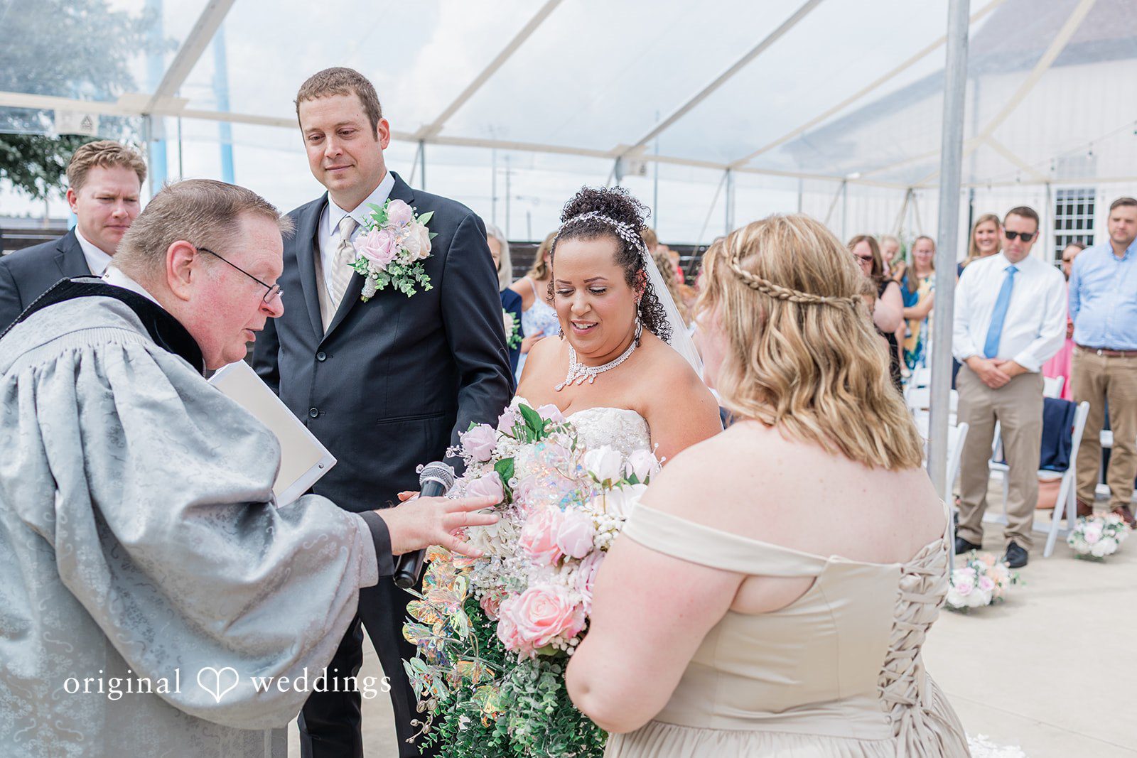 Daniel + Dalte An officiant speaks to a bride and groom during a wedding ceremony.