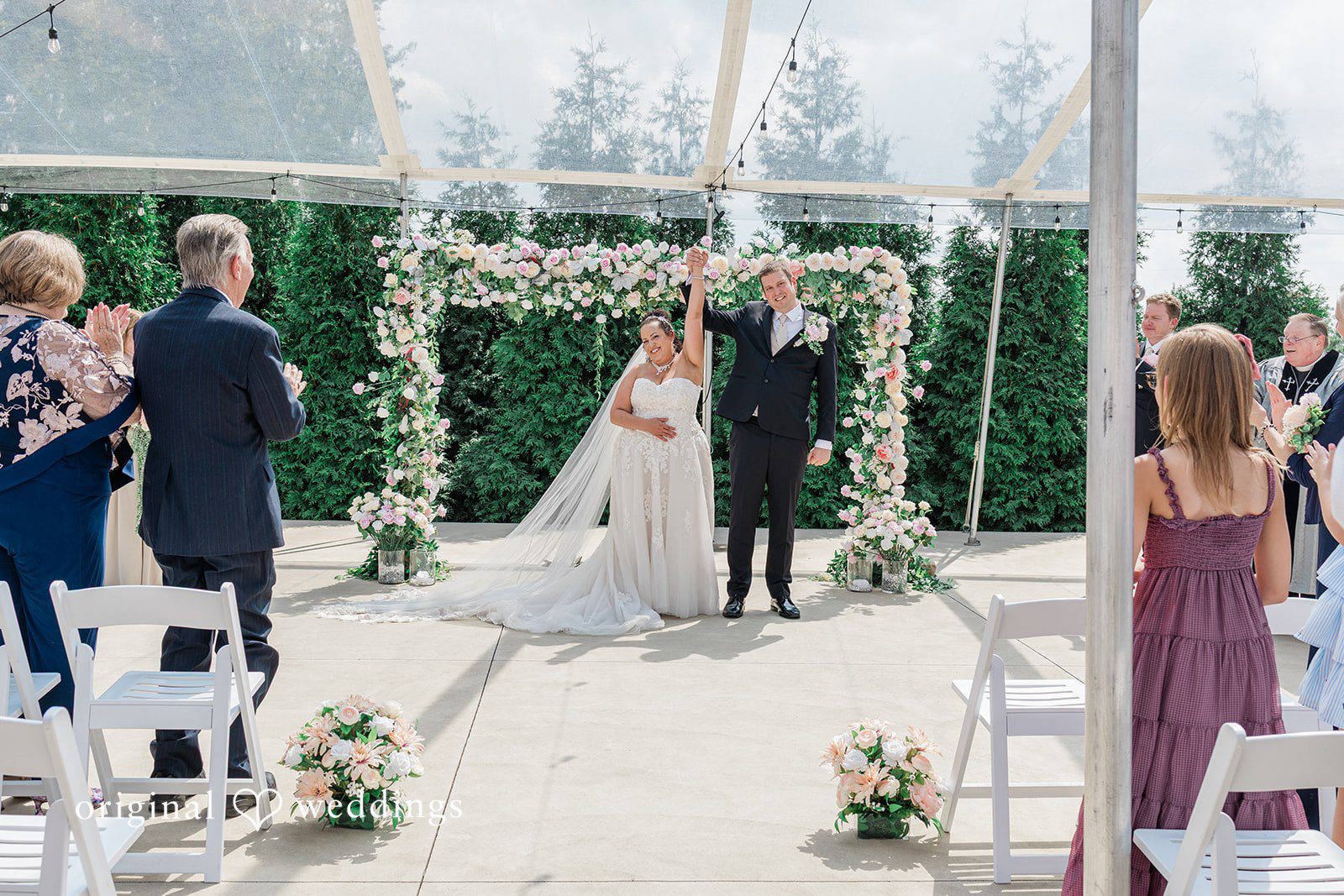 Daniel + Dalte A bride and groom stand together at the altar under a floral archway.