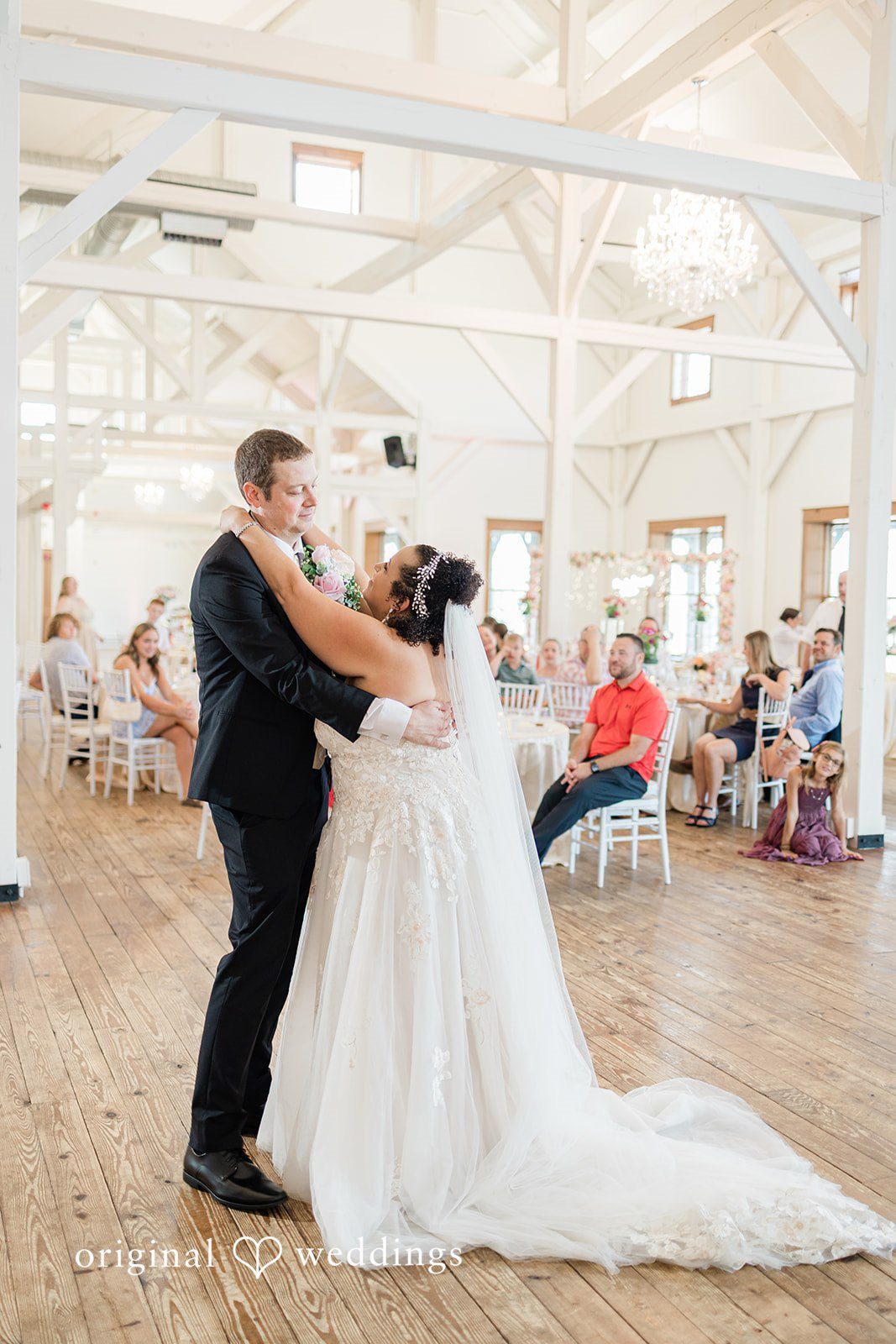 Daniel + Dalte A bride and groom sharing a dance on a wooden floor during their reception.