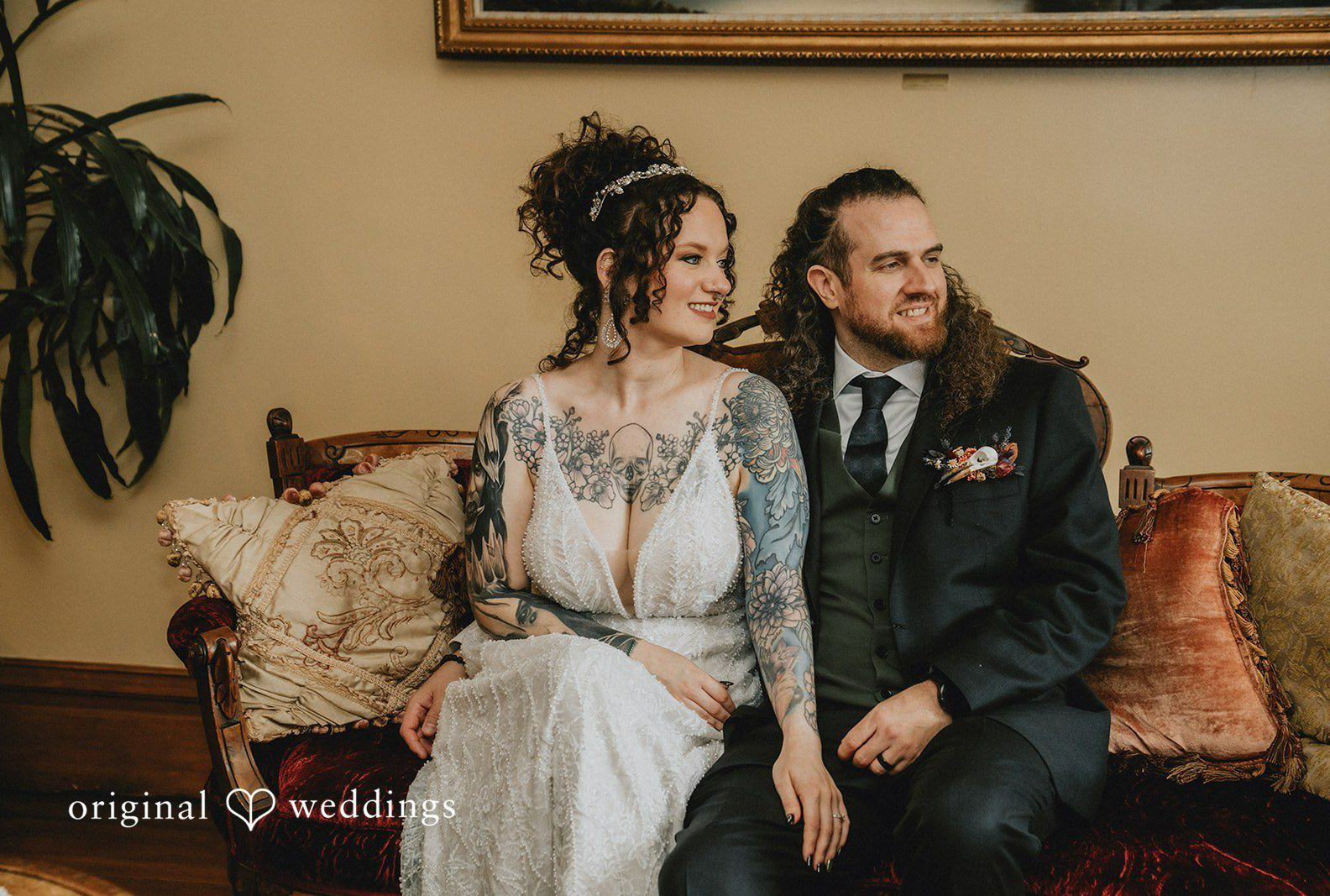 Ashlie and Robert sitting together on a vintage sofa, captured by Portland wedding photographers from Original Weddings at The Victorian Belle Mansion