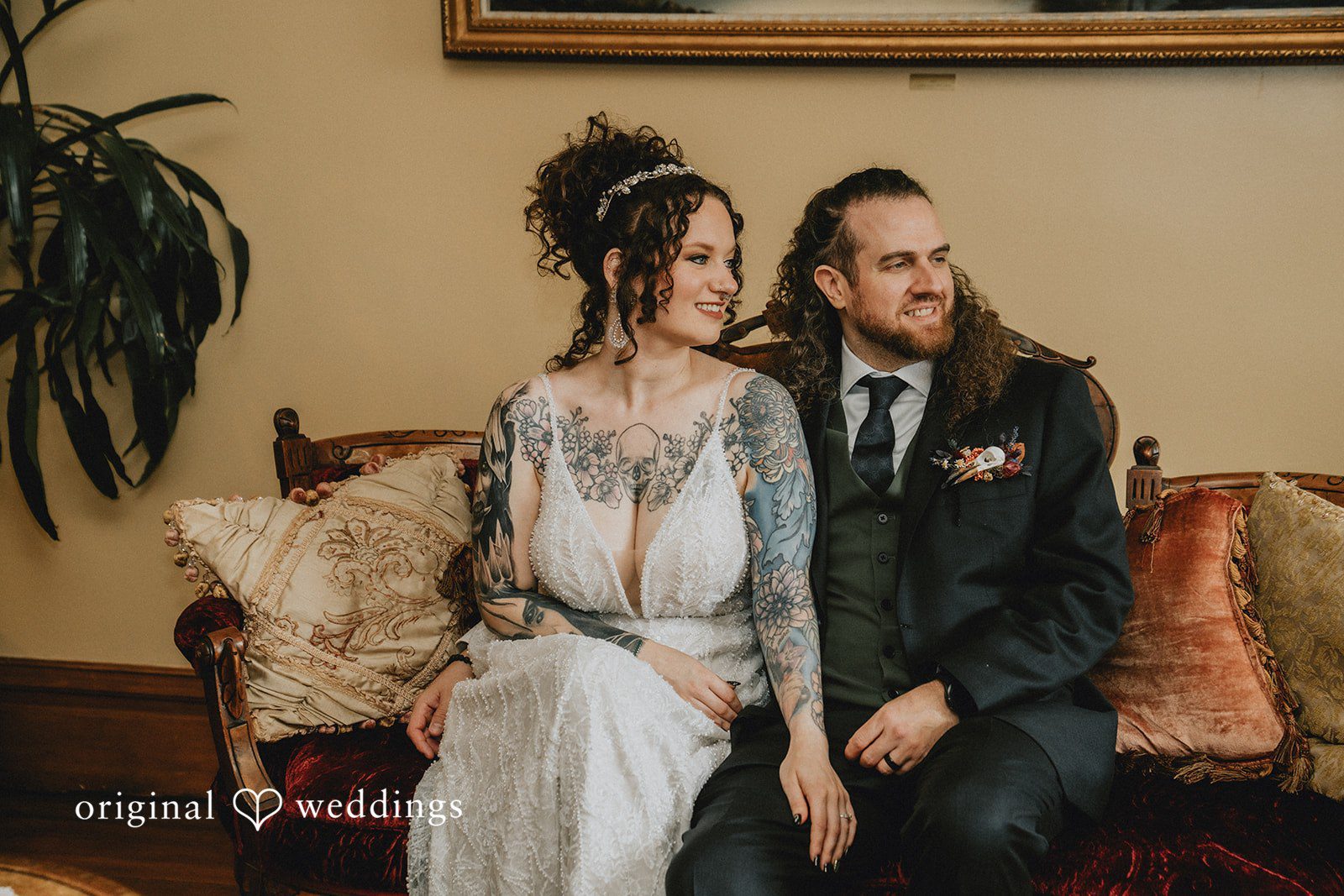 Ashlie and Robert sitting together on a vintage sofa, captured by Portland wedding photographers from Original Weddings at The Victorian Belle Mansion