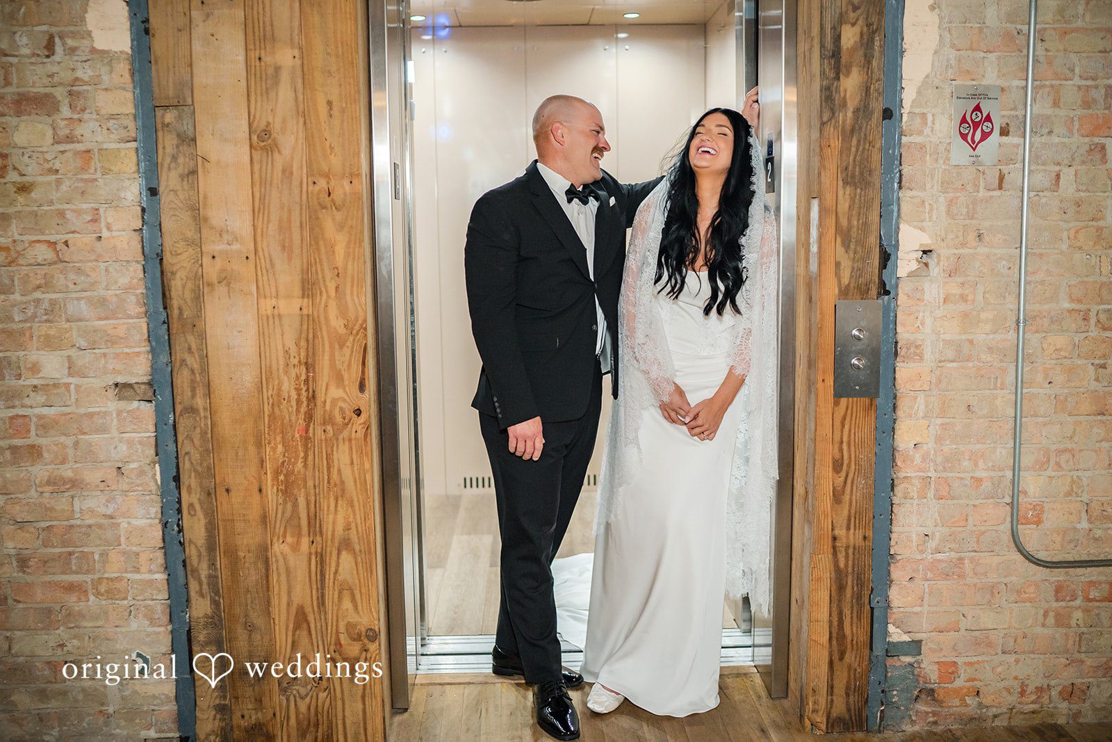 August 01, 2026 – Haley & Austin – (ID-4892) A bride and groom holding hands while posing together in front of a neutral backdrop.