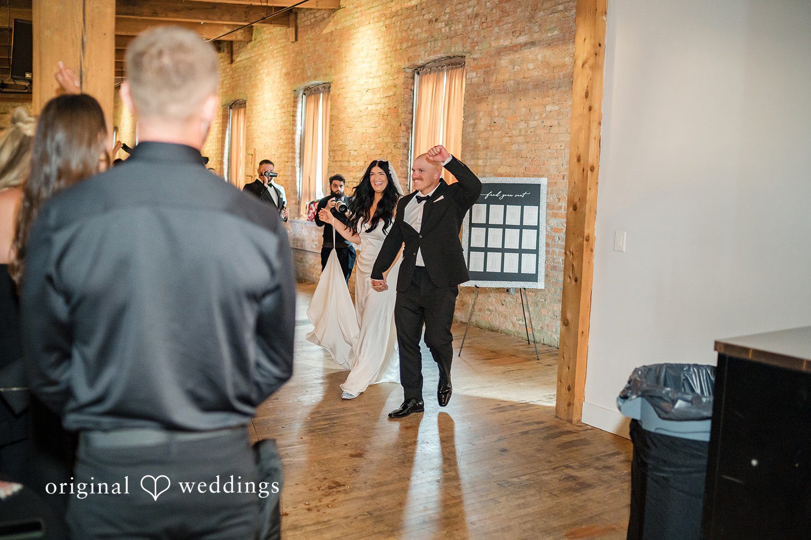 August 01, 2026 – Haley & Austin – (ID-4892) A groom seen from behind walking down a long corridor with large windows.
