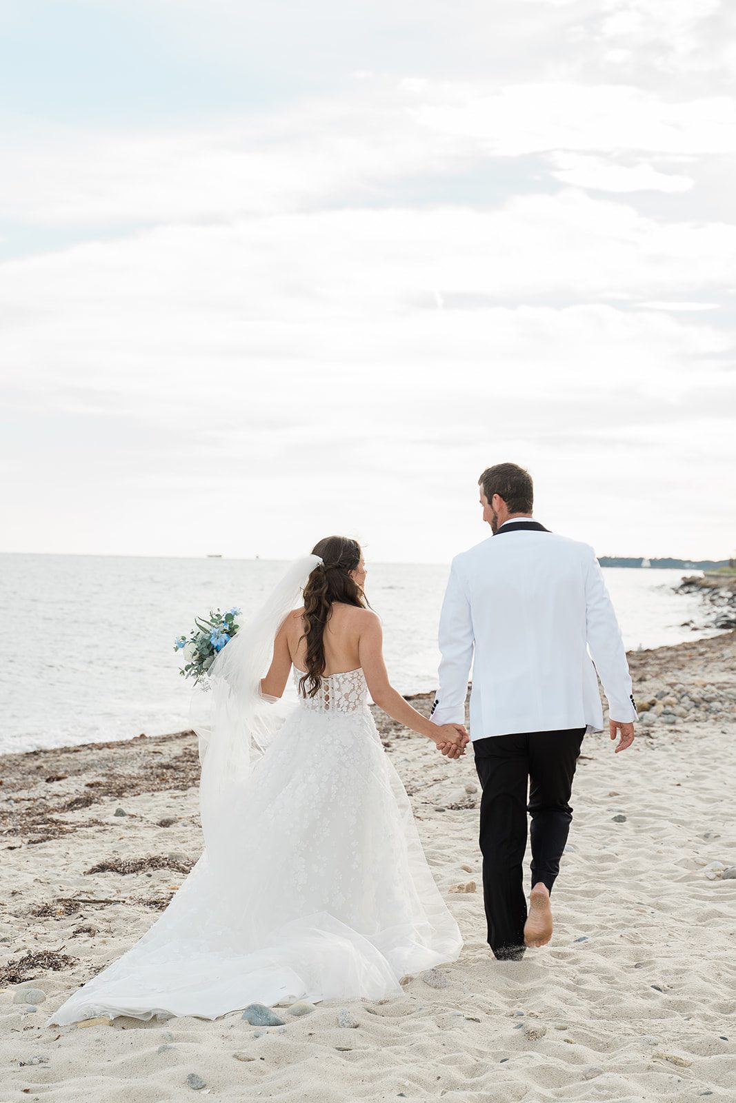 the-wharf-airy-boston-lia-cam-021-41 Couple walking on the beach, captured by Boston wedding photographers from Original Weddings at The Wharf