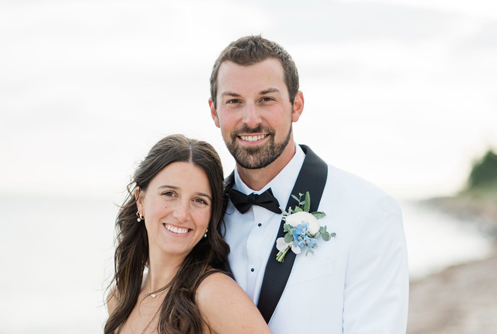 Bride and groom smiling together on the beach, captured by Boston wedding photographers from Original Weddings at The Wharf