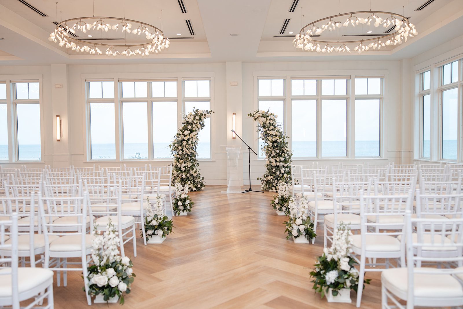 Indoor ceremony room with white floral arches at The Wychmere