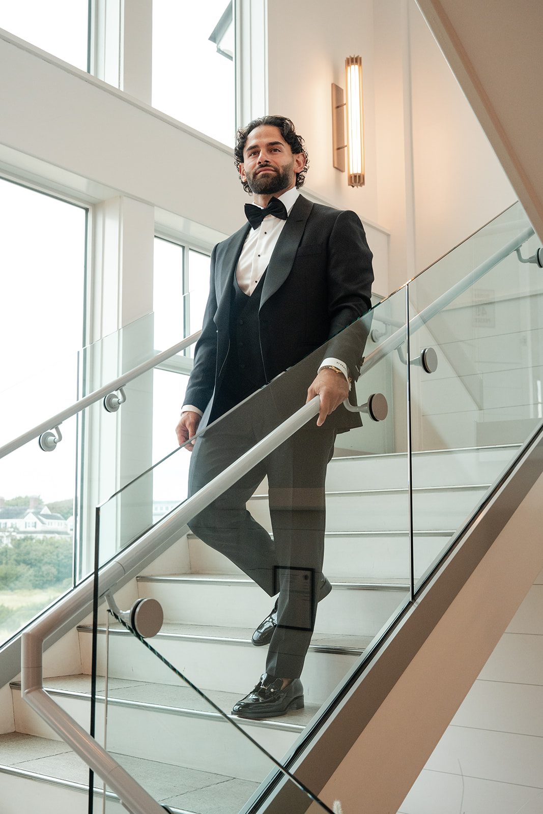 Groom walking down the glass staircase at The Wychmere