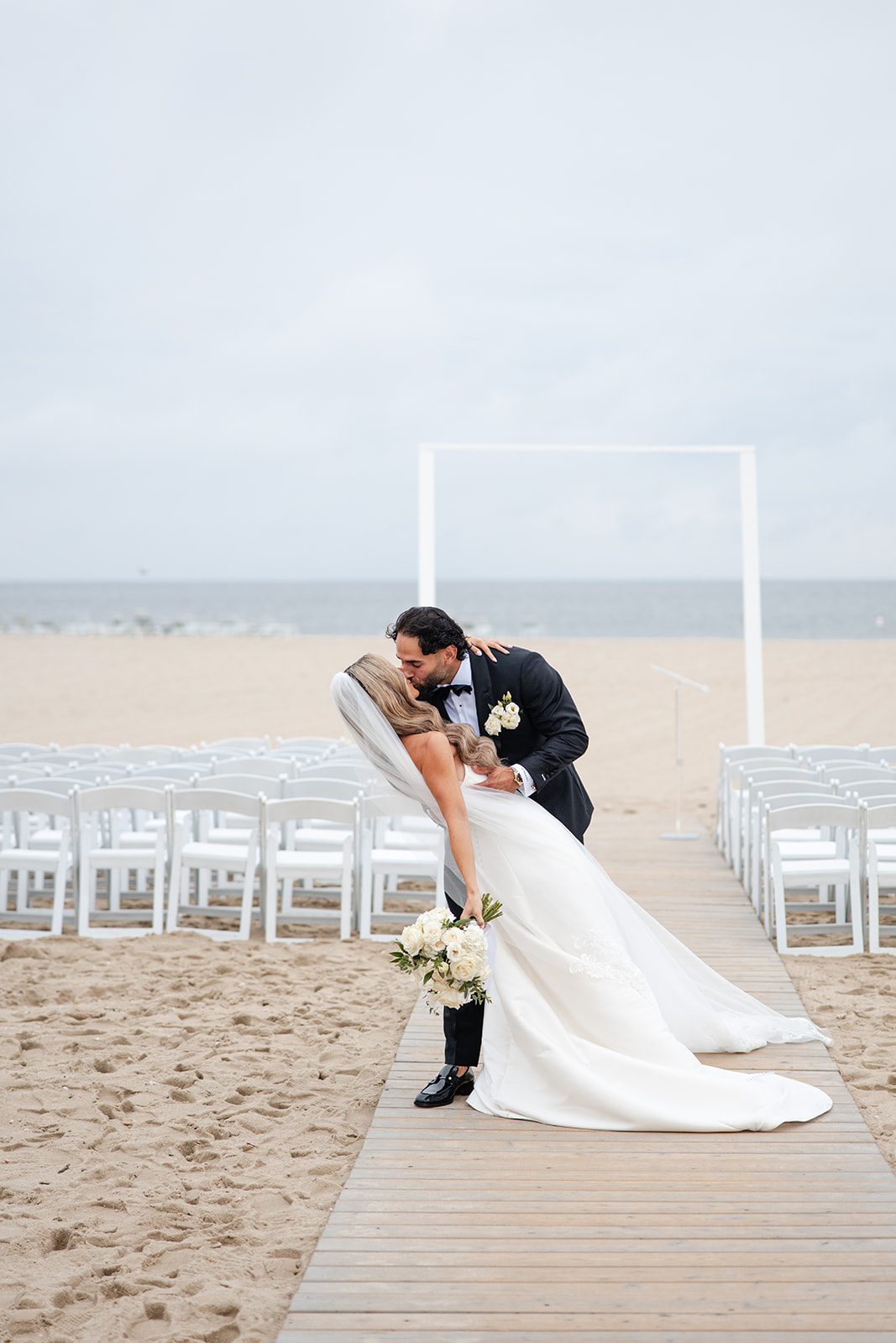 Groom dipping the bride on the beach at The Wychmere