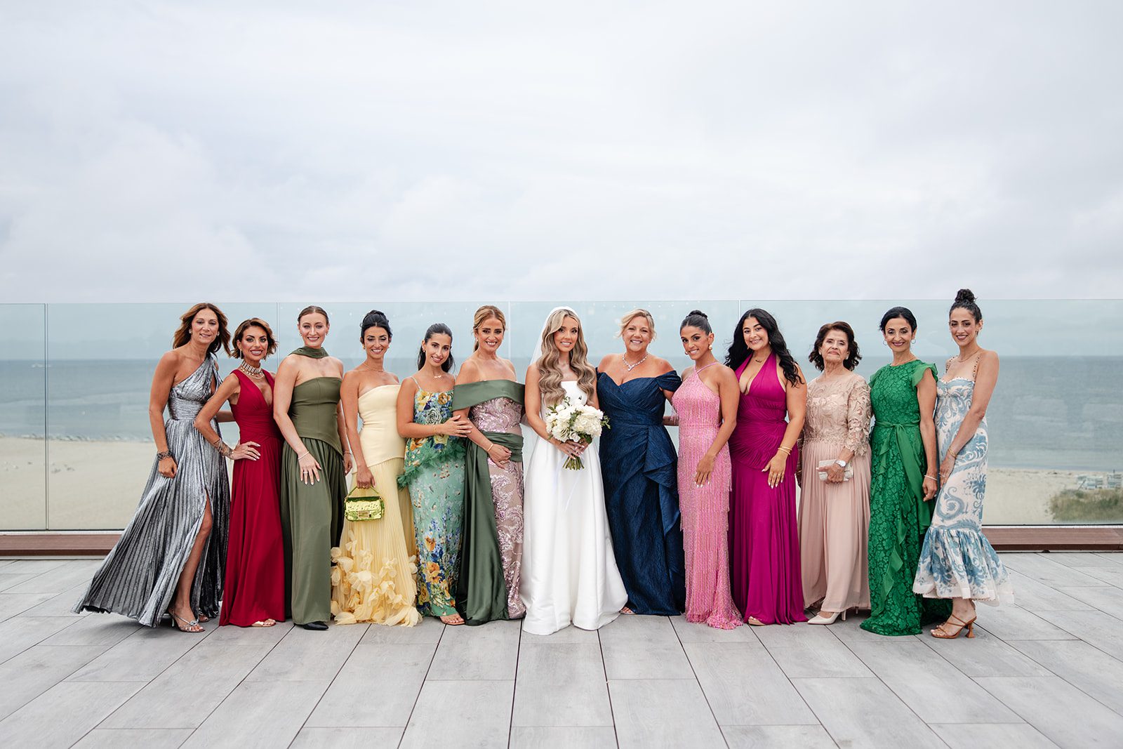 Bridesmaids in colorful gowns by the water at The Wychmere
